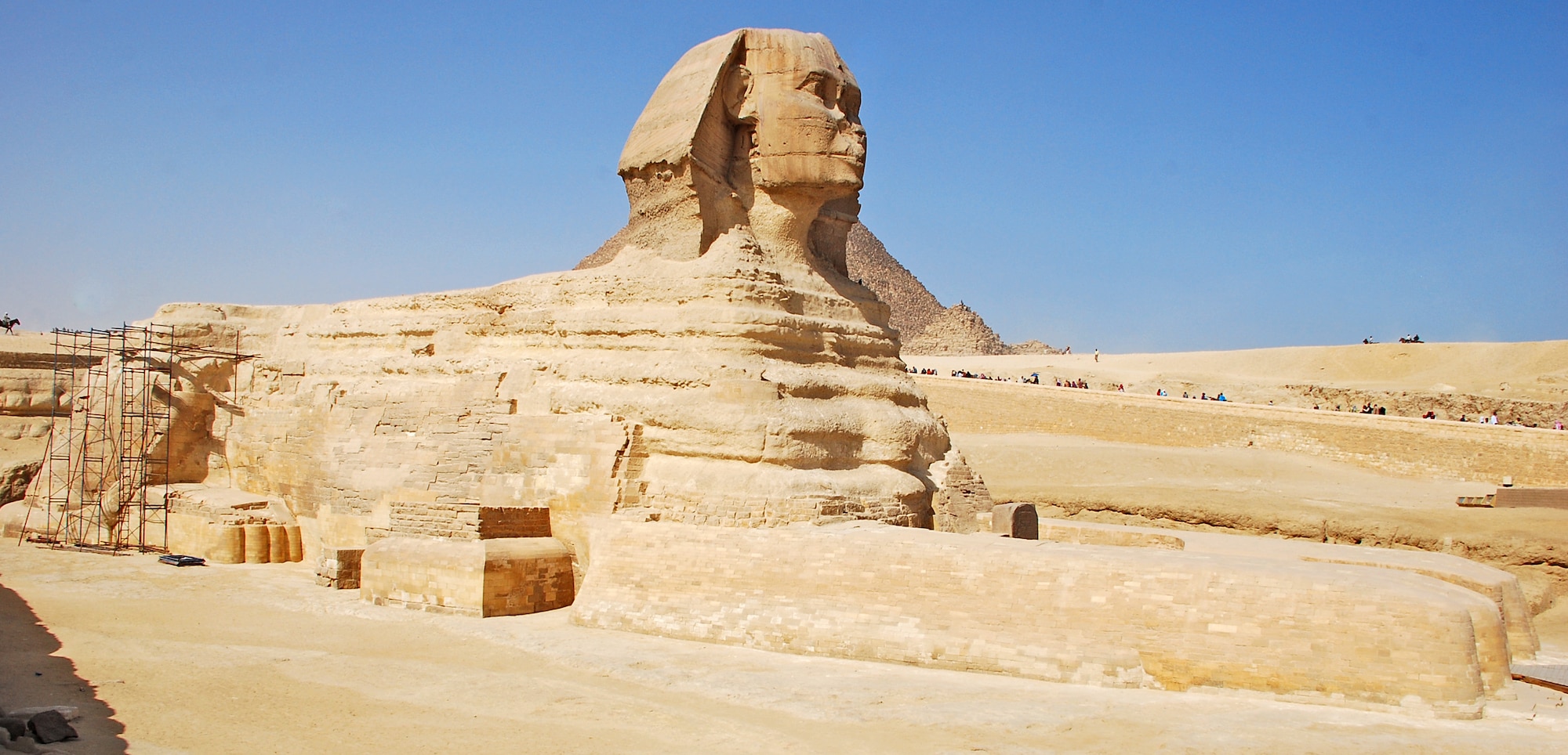 The Great Sphinx of Giza lies on the Giza Plateau with the famous Pyramids of Giza just in the distance, near Cairo, Egypt. The Sphinx is a statue of a reclining lion with a human head that is believed to have been built by ancient Egyptians between 2555 B.C. and 2523 B.C. It is one of the most famous and recognizable pieces of history in the Cairo area. (U.S. Air Force photo/Senior Airman Sara Csurilla)