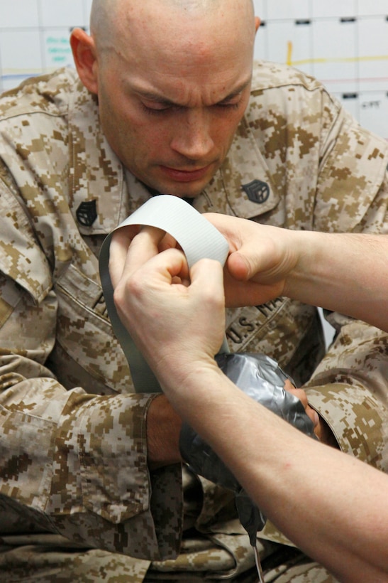 Staff Sgt. Robert Pippin, exercise hostage, has his hands taped to the simulated victimoperated switch to ensure his safety as well as all property during an exercise held at the Explosive Ordnance Disposal building here April 2. EOD Marines are conducting a two-week block of instruction in advanced category A type devices.
