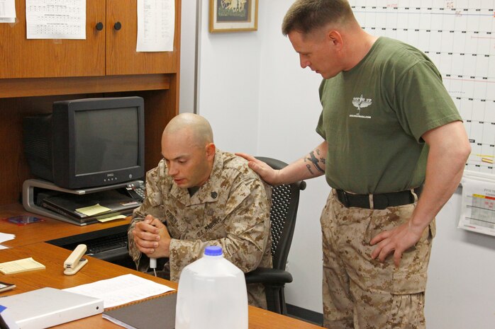 Gunnery Sgt. Hugh McClenney, staff noncommissioned officer in charge with station Explosive Ordnance Disposal, talks to the simulated hostage, Staff Sgt. Robert Pippin, to calm him down during an exercise at the EOD building here April 2. During the exercise, EOD Marines were faced with a difficult situation of rendering safe the hostage from an Improvised explosive device.