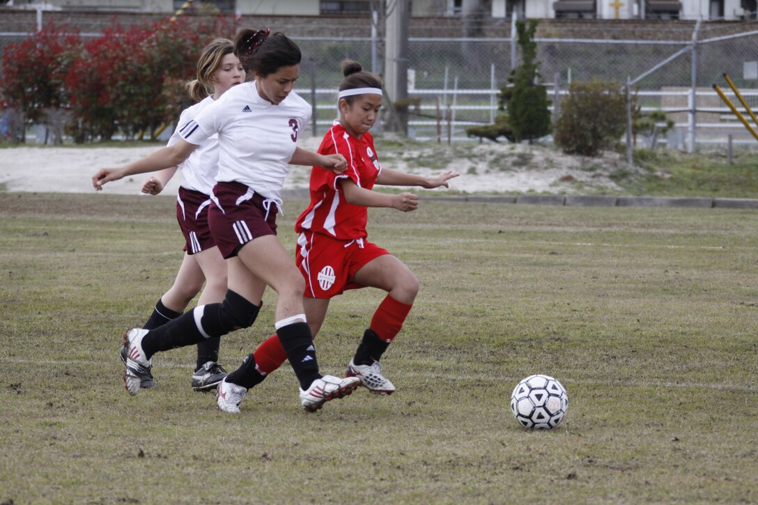 Victoria Pelletier, Matthew C. Perry High School player, races against Yvette Jamosmos, a Kinnick High School player, to gain control of the ball during the girl’s soccer match at M.C. Perry High School soccer field here April 2.