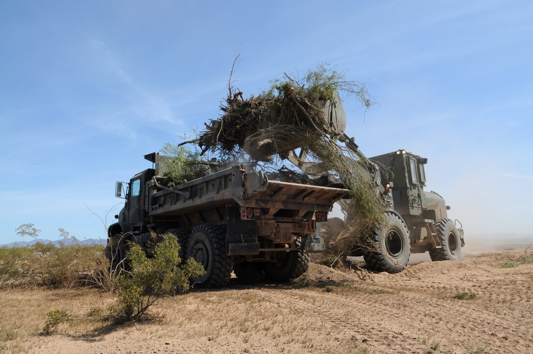 A Marine Wing Support Squadron 371 John Deere four-wheel loader drops debris into a dump truck at Auxiliary Airfield 6 on the range April 3, 2010. The range is located 7 miles south of Gila Bend, Ariz. Fourteen of the squadron's Marines worked for four days clearing 36,000 square feet of runway in support of the upcoming Weapons and Tactics Instructor course.