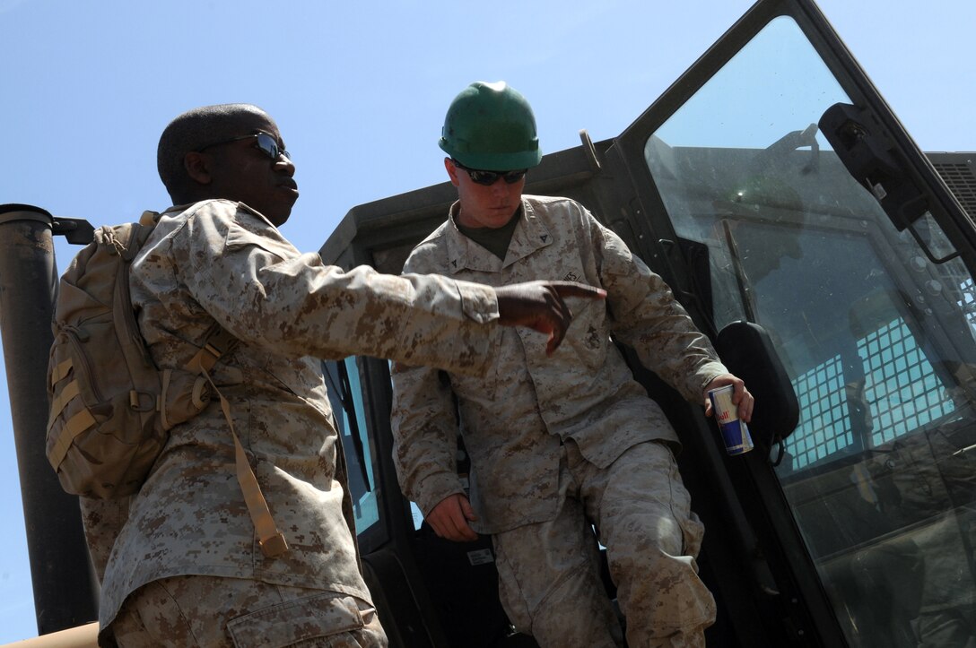 Staff Sgt. Byron Keys, left, heavy equipment platoon operations chief, tells Lance Cpl. Sean King, squadron heavy equipment operator, where to begin clearing foliage at Auxiliary Airfield 6 on April 3, 2010. The range is located 7 miles south of Gila Bend, Ariz. The Marine Wing Support Squadron 371 Marines worked for four days clearing 36,000 square feet of runway in support of the upcoming Weapons and Tactics Instructor course.