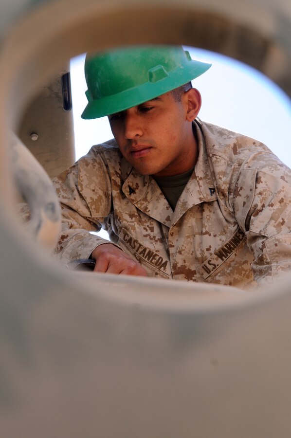 Lance Cpl. Danial Castaneda, Marine Wing Support Squadron 371 heavy equipment operator, checks to ensure the bucket of a John Deere four-wheel loader is clear of tree branches and shrubs at Auxiliary Airfield 6 on April 3, 2010. The range is located 7 miles south of Gila Bend, Ariz. The squadron had 14 of its Marines work for four days clearing 36,000 square feet of runway in support of the upcoming Weapons and Tactics Instructor course.