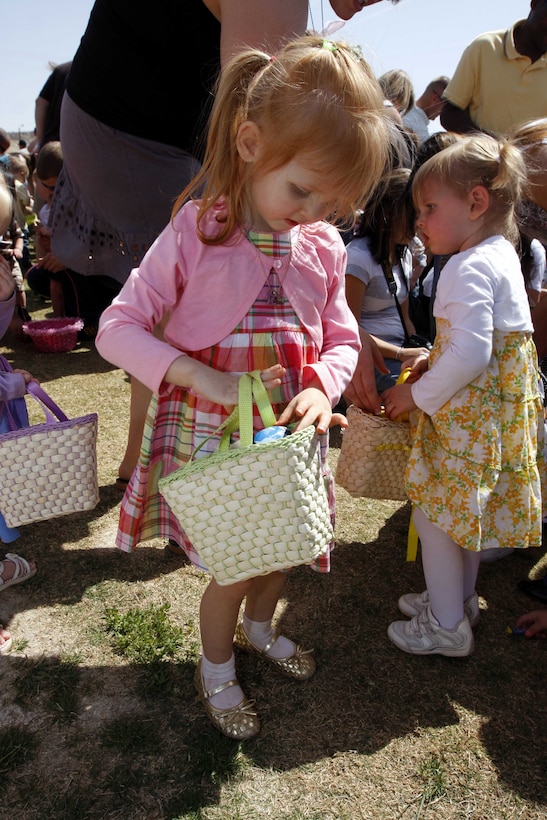 MARINE CORPS AIR GROUND COMBAT CENTER TWENTYNINE PALMS, Calif. - Scarlet Buerkley, the daughter of Sgt. Logan Buerkley, a motor transportation operator with Marine Unmanned Vehicle Squadron 3, places a recently-discovered egg in her basket April 3 during the Combat Center's Spring Egg Hunt at Felix Field. The event also featured games, cotton candy and pictures with Peter Cotton Tail.