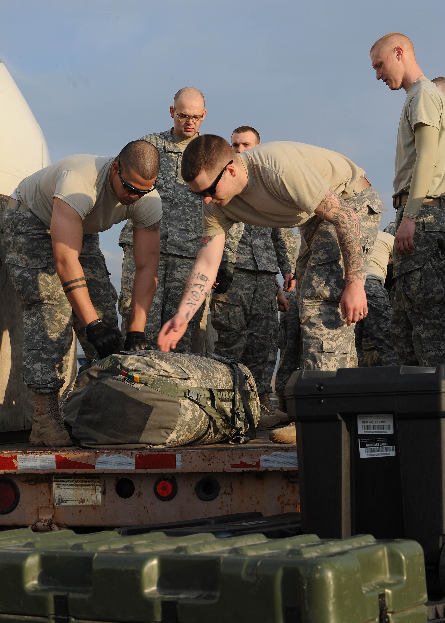 U.S. Army Specialists David Aviles and Noah Bond, 557th Engineer Company, 864th Engineer Battalion, Ft. Lewis, Wash., load baggage onto a truck after arriving at the Transit Center at Manas, Kyrgyzstan, April 1, 2010. The Soldiers are en route to Kandahar, Afghanistan. The 376th Expeditionary Logistics Readiness Squadron broke their own record in March for most passengers moved through here, at the "gateway to Afghanistan." The passenger terminal pushed through 50,000 multi-national, U.S. and coalition troops. (U.S. Air Force photo/Senior Airman Nichelle Anderson/released)