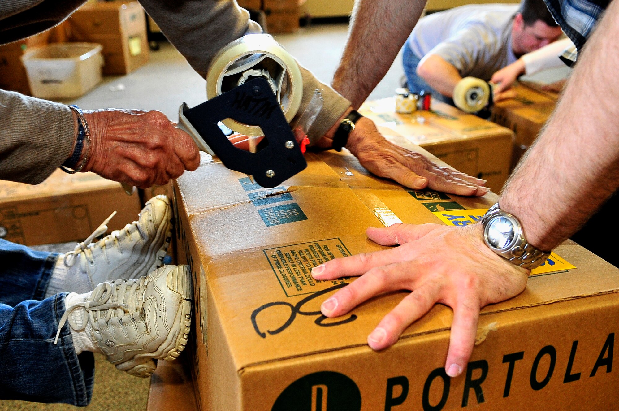BUCKLEY AIR FORCE BASE, Colo. -- Volunteers from Buckley Air Force Base and the local community package boxes of cookies for Hearts Across the Miles March 14. These cookies will be shipped to U.S. troops deployed in Iraq and Afghanistan. (U.S. Air Force photo by Staff Sgt. Kathrine McDowell)
