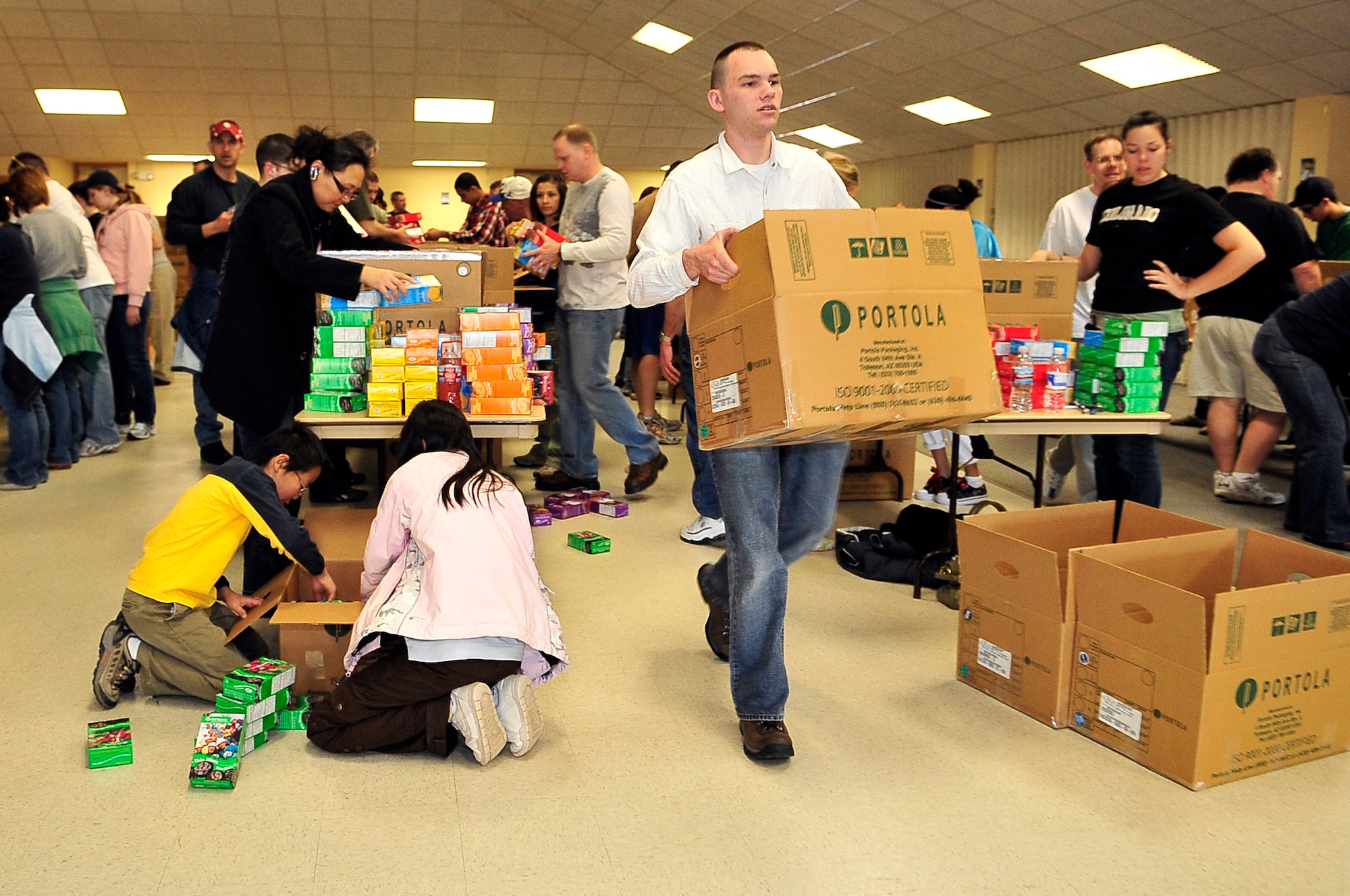 BUCKLEY AIR FORCE BASE, Colo. -- Senior Airman James Swann, 460th Space Communications Squadron, volunteers at a cookie drive for Hearts Across the Miles March 14. Airman Swann helped package more than 300 boxes of cookies for deployed U.S. troops. (U.S. Air Force photo by Staff Sgt. Kathrine McDowell)