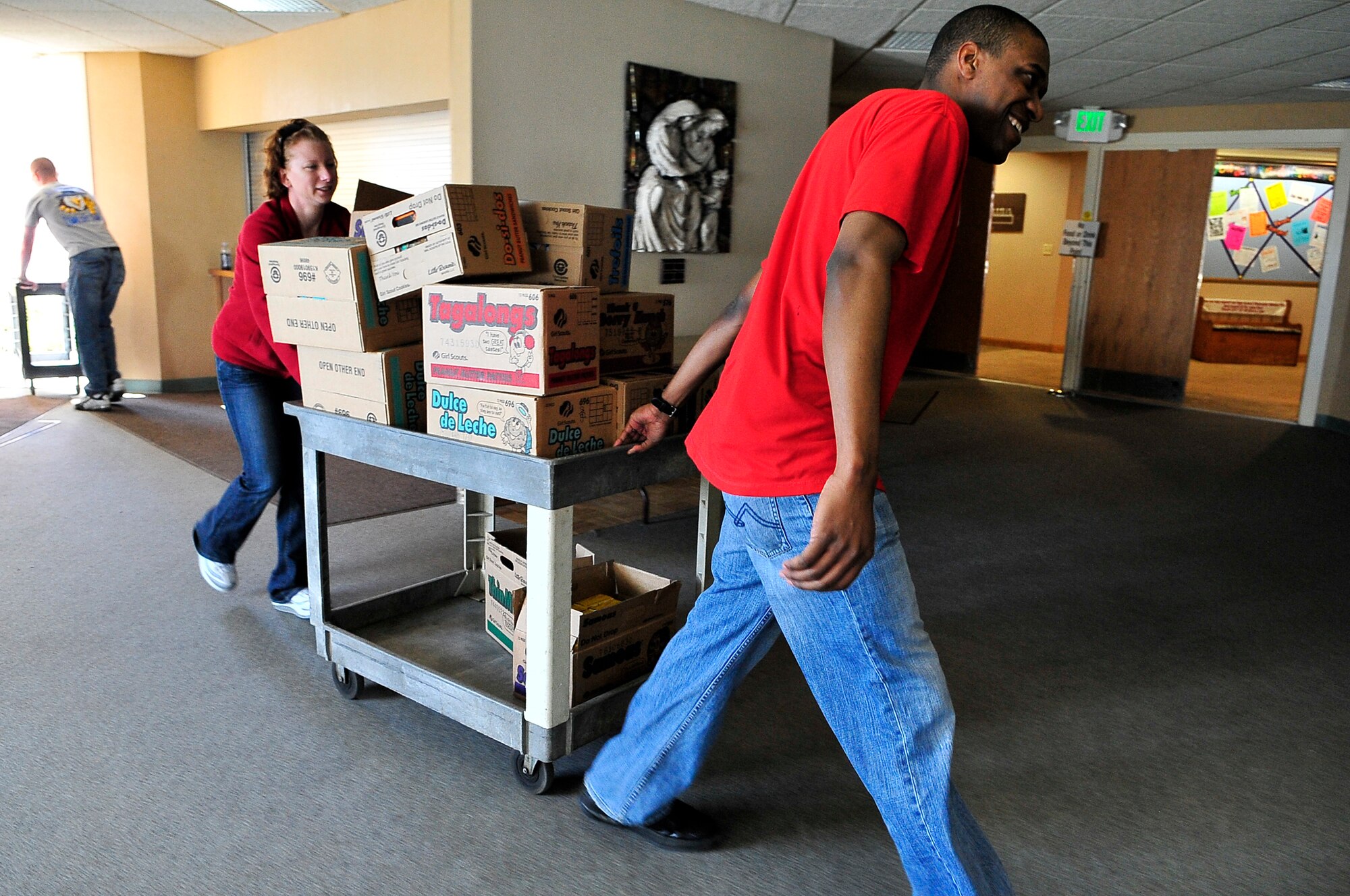 BUCKLEY AIR FORCE BASE, Colo. -- Staff  Sgt. Kristen Porter, Air Force Technical Applications Center  Detachment 45, left, and Senior Airman Darnell Walcott, 460th Space Communications Squadron program manager, volunteer for Hearts Across the Miles March 14. Sergeant Porter and Airman Walcott helped package more than 300 cases of cookies for deployed U.S. troops in Iraq and Afghanistan. (U.S. Air Force photo by Staff Sgt. Kathrine McDowell)