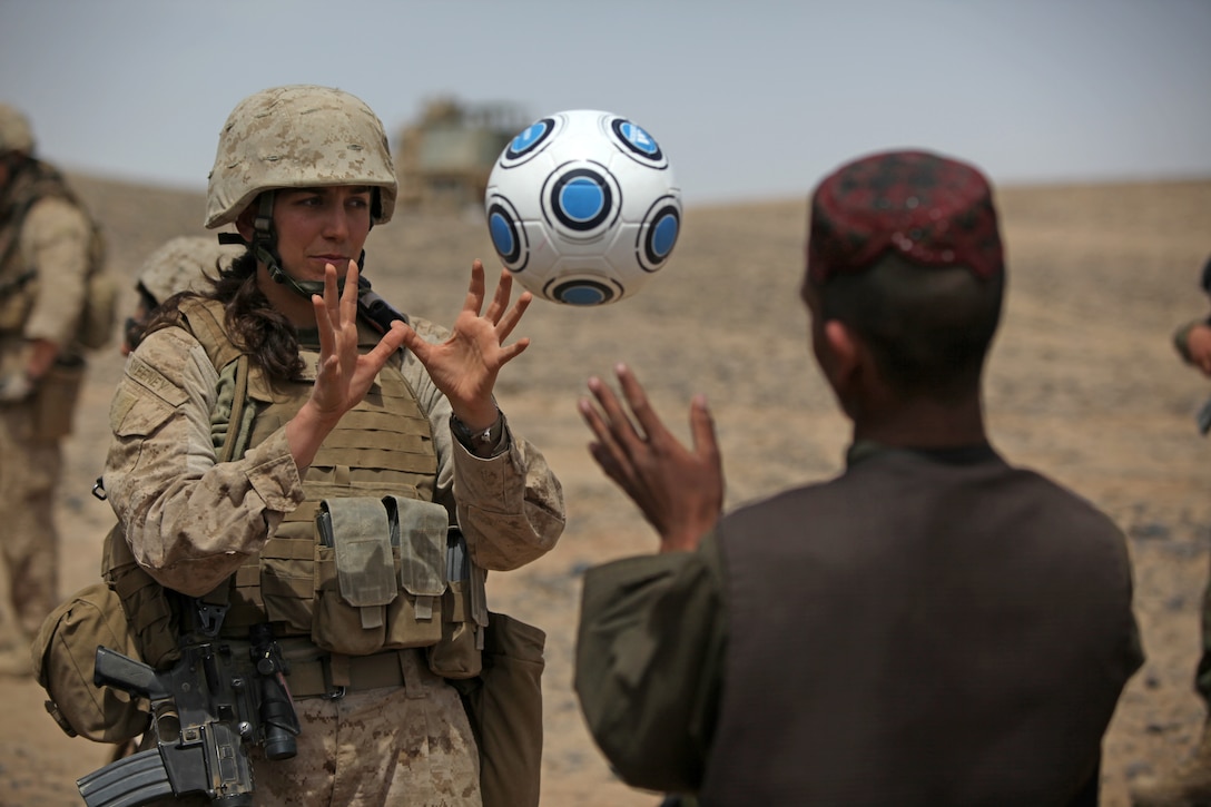 2nd Lt. Casie Sweeney, team leader, Female Engagement Team, I Marine Expeditionary Force Forward, tosses a soccer ball with a local Afghan while visiting settlements April 5. The FET engaged in conversation with women of the area in effort to better gain cultural awareness and ascertain family needs in support of efforts of the International Security Assistance Force assigned to the region.