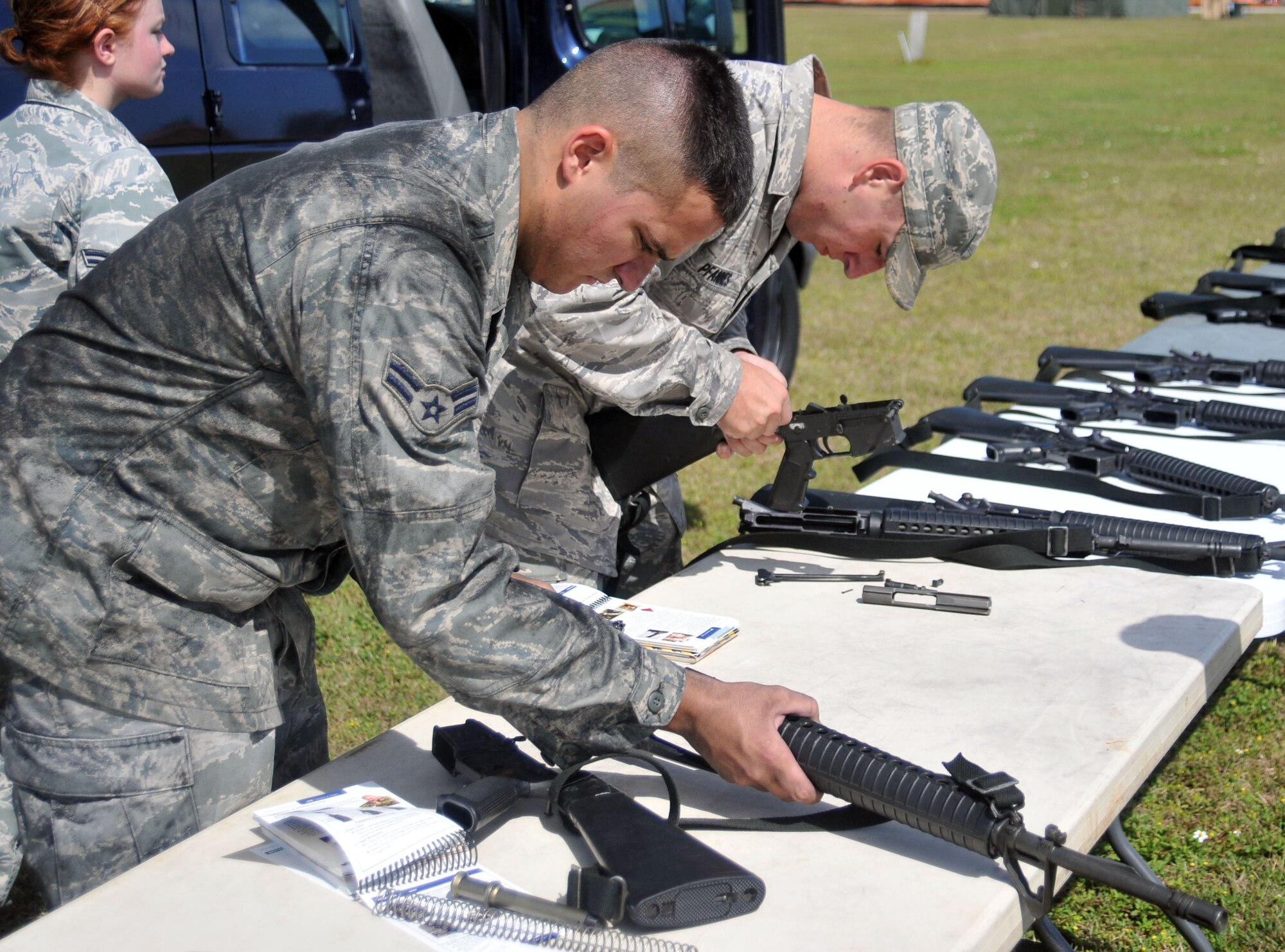 ANDERSEN AIR FORCE BASE, Guam - Airman 1st Class Kylie Krzywiecki and Airman 1st Class Matthew Pfannes attempt to successfully take apart and put back together an M-16 during the wing's Abilitiy To Survive and Operate Rodeo here March 30. (U.S. Air Force photo by Airman 1st Class Julian North)