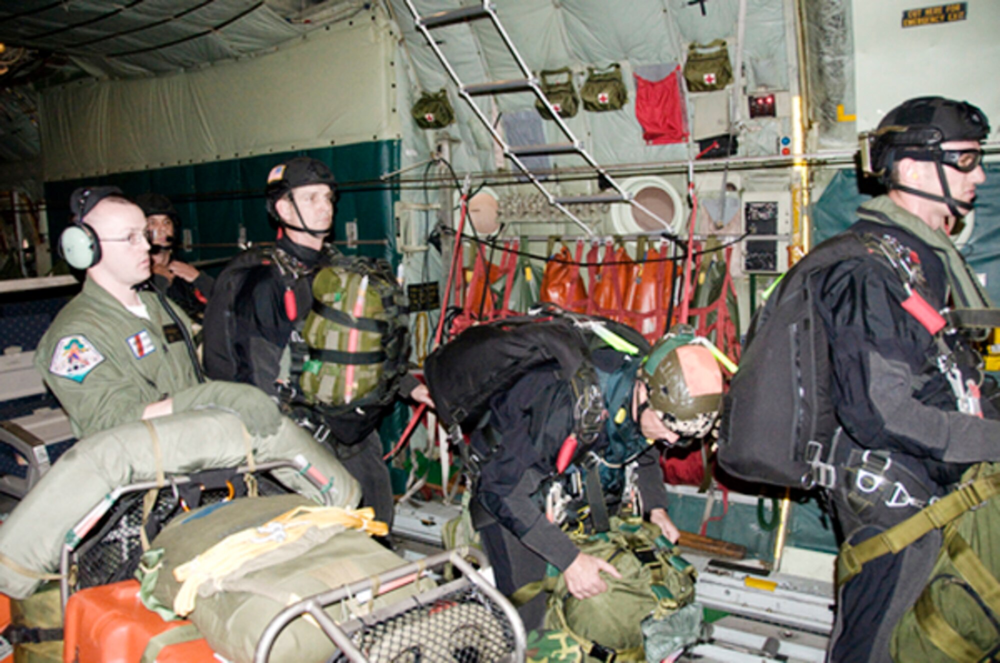 Pararescuemen from the California Air National Guard's 129th Rescue Wing prepare to jump from the rear door of a Coast Guard HC-130 Hercules April 1, 2010, approximately 1,400 miles southwest of San Diego.  The Coast Guard and Air National Guard personnel worked together to rescue an injured 57-year-old sailor by dropping four pararescuemen, an inflatable boat and other rescue and survival equipment near his sailing vessel . (U.S. Coast Guard photo/Petty Officer 3rd Class Henry G. Dunphy)