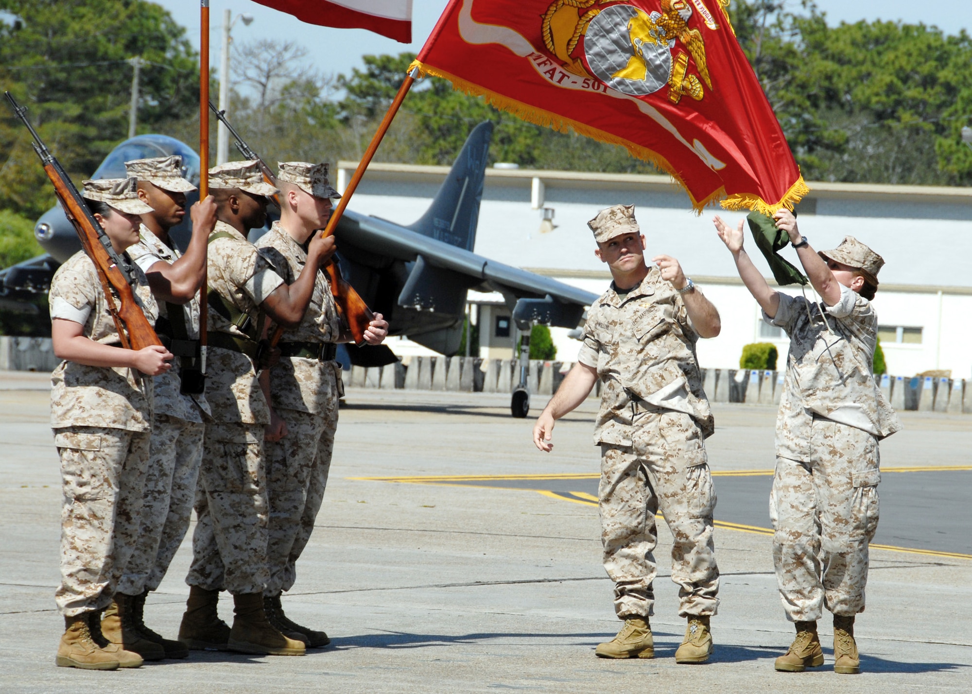 Marine Lt. Col. James Wellons and Marine Sgt. Maj. Bonnie Skinner unfurl the new flag officially redesignating the squadron April 2 at Eglin Air Force Base, Fla. The Marine Fighter Attack Training Squadron 501 is the first Marine JSF squadron and also the first Marine squadron embedded into an Air Force wing. Colonel Wellons is the VMFAT-501 commander and Sergeant Skinner is the VMFAT-501 sergeant major. (U.S. Air Force photo/Samuel King Jr.)