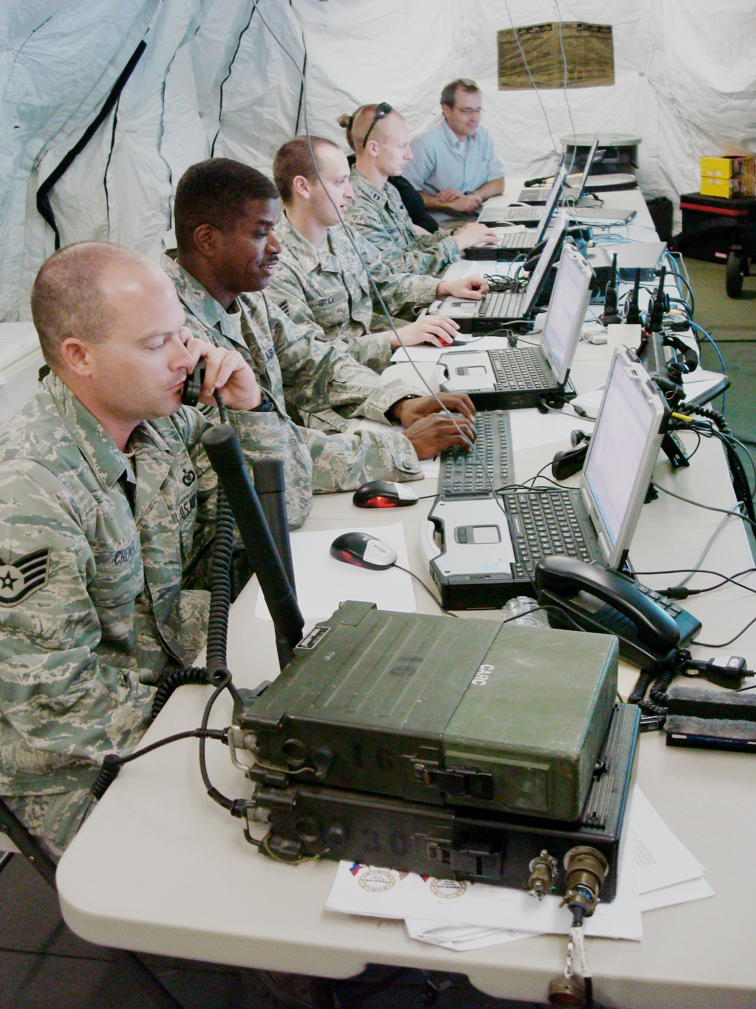 Staff Sgt. Justin Cremer (left to right), Tech. Sgt. Christopher Currie, Staff Sgt. Jason Bruce and Capt. Timothy Swierzbin work together using a common operational picture along with Jeff Oakerson to deconflict aircraft participating in Exercise Balikatan March 20, 2010, in the Philippines. Balikatan is an annual bilateral exercise designed to increase interoperability between the U.S. and Philippine air forces, and exercises the two nation's ability to operate together when responding to natural disasters. The Airmen are from the 25th Air Support Operations Squadron at Joint Base Pearl Harbor-Hickam, Hawaii, and Mr. Oakerson is from CACI International Inc. (U.S. Air Force photo)