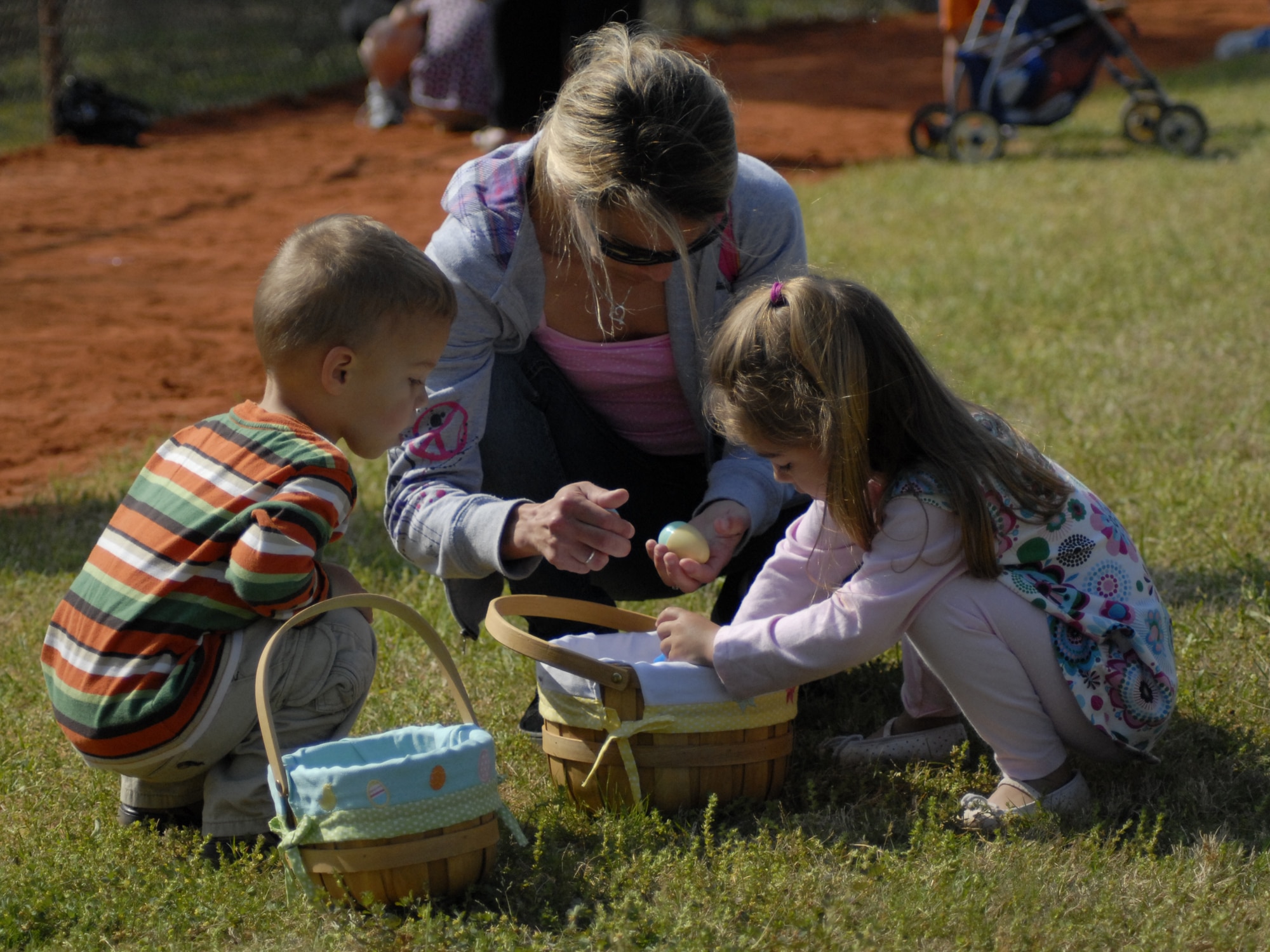 Christina Hoffman, center, helps sort through her daughter Aleyah's, 3, basket as her son Tristan, 2, looks on at the tenth annual Family Fest and Egg Hunt at the Hurlburt Field Community Park April 3. The event was coordinated by the 1st Special Operations Force Support Squadron and sponsoring agencies for family entertainment during the holiday weekend. (U.S. Air Force photo by Airman 1st Class Joe McFadden)