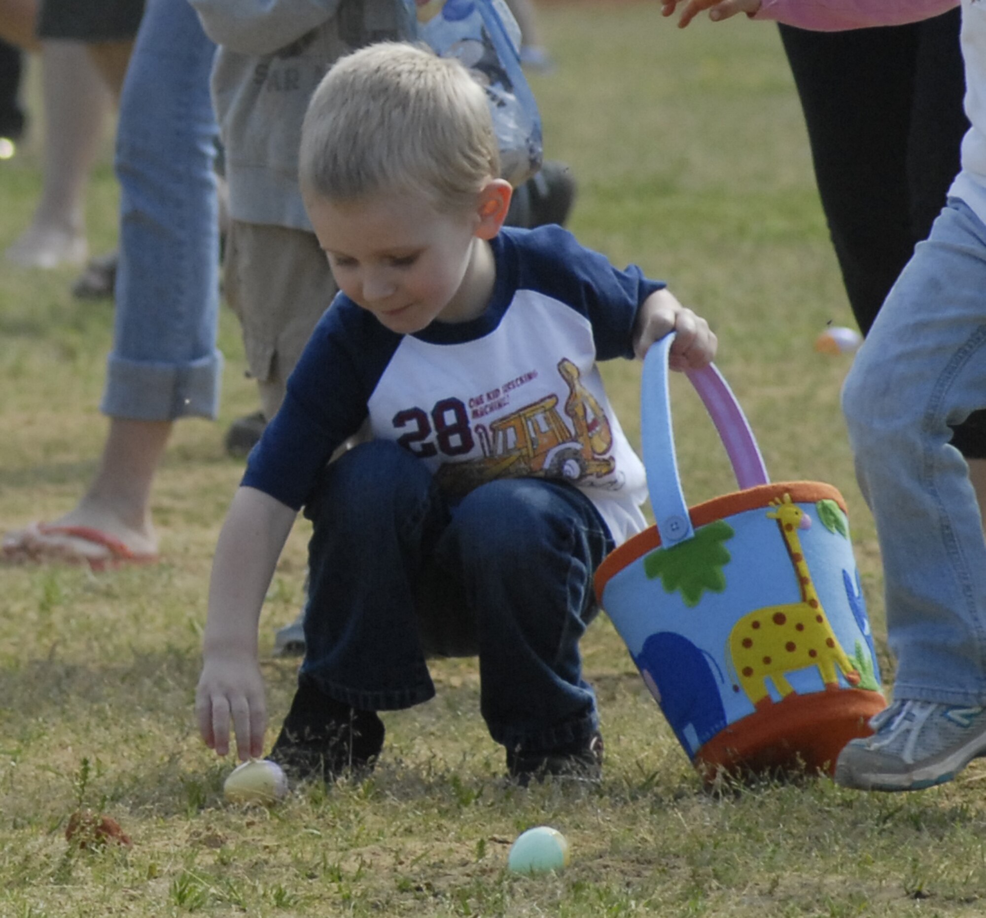 A child picks up an egg at the tenth annual Family Fest and Egg Hunt at the Hurlburt Field Community Park April 3. Within a minute, the children snatched up nearly 16,000 candy and treat-filled eggs. (U.S. Air Force photo by Airman 1st Class Joe McFadden)
