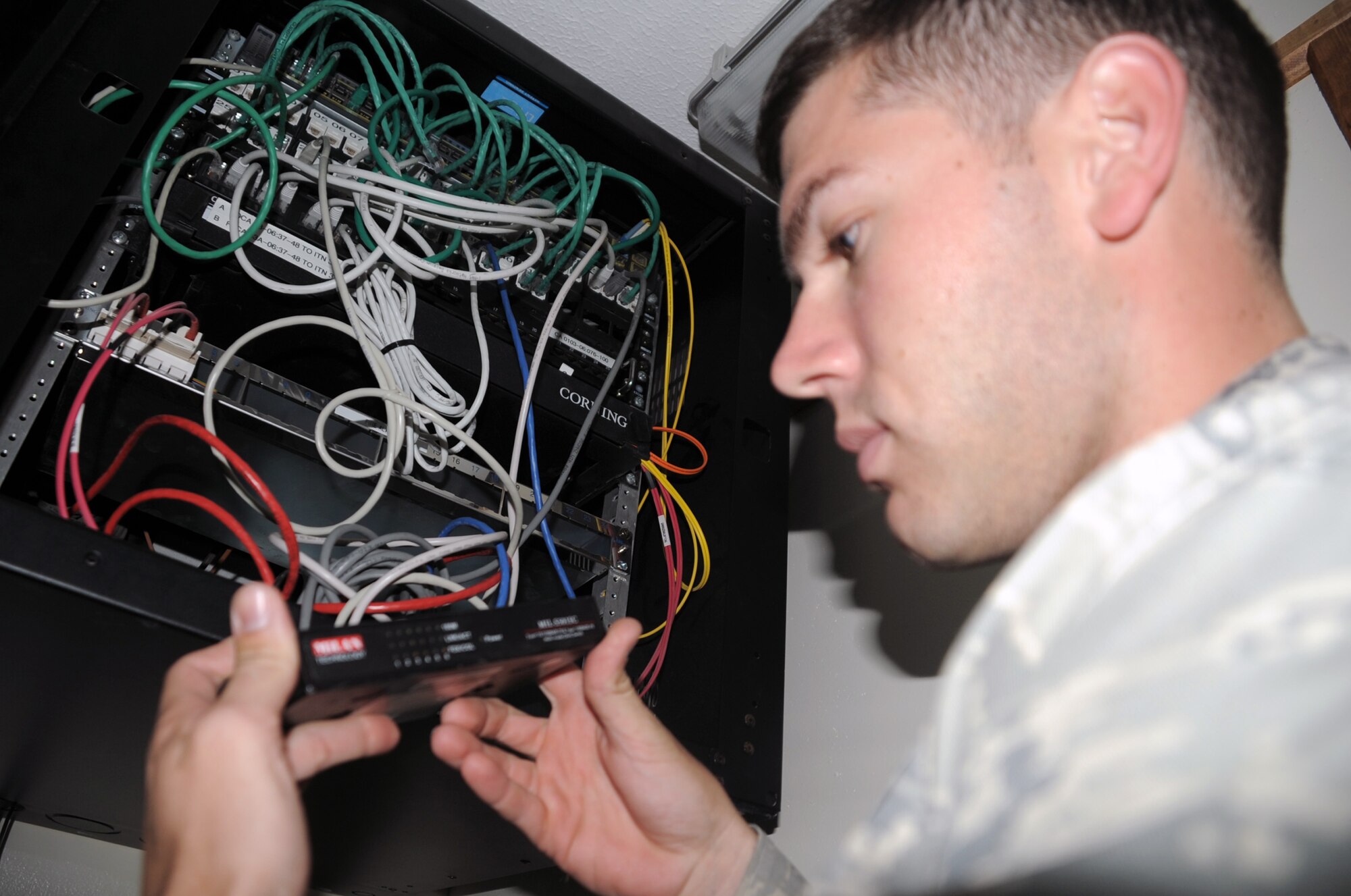 Senior Airman Matthew Glynn, client systems journeyman with the 380th Expeditionary Communications Squadron, works on computer network equipment in a base buidling during operations at a non-disclosed base in Southwest Asia on April 5, 2010. According to his official Air Force job description, client systems personnel are the Air Force computer networking specialists. When they are deployed, they sustain, troubleshoot and repair standard voice, data, video network and cryptographic client devices. Airman Glynn is deployed from the 92nd Communications Squadron at Fairchild Air Force Base, Wash., and his hometown is Larose, La. (U.S. Air Force Photo/Master Sgt. Scott T. Sturkol/Released)