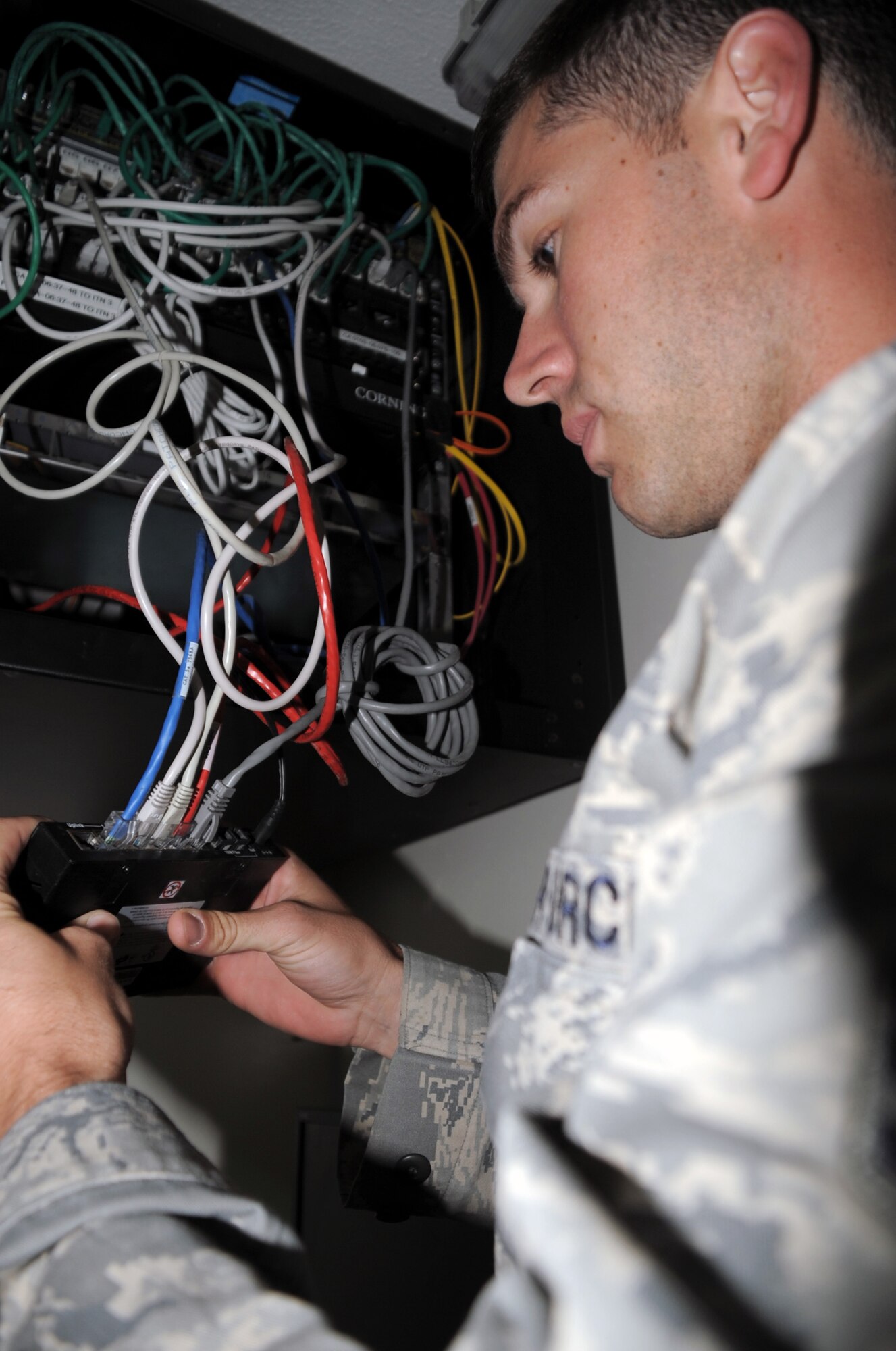 Senior Airman Matthew Glynn, client systems journeyman with the 380th Expeditionary Communications Squadron, works on computer network equipment in a base buidling during operations at a non-disclosed base in Southwest Asia on April 5, 2010. According to his official Air Force job description, client systems personnel are the Air Force computer networking specialists. When they are deployed, they sustain, troubleshoot and repair standard voice, data, video network and cryptographic client devices. Airman Glynn is deployed from the 92nd Communications Squadron at Fairchild Air Force Base, Wash., and his hometown is Larose, La. (U.S. Air Force Photo/Master Sgt. Scott T. Sturkol/Released)