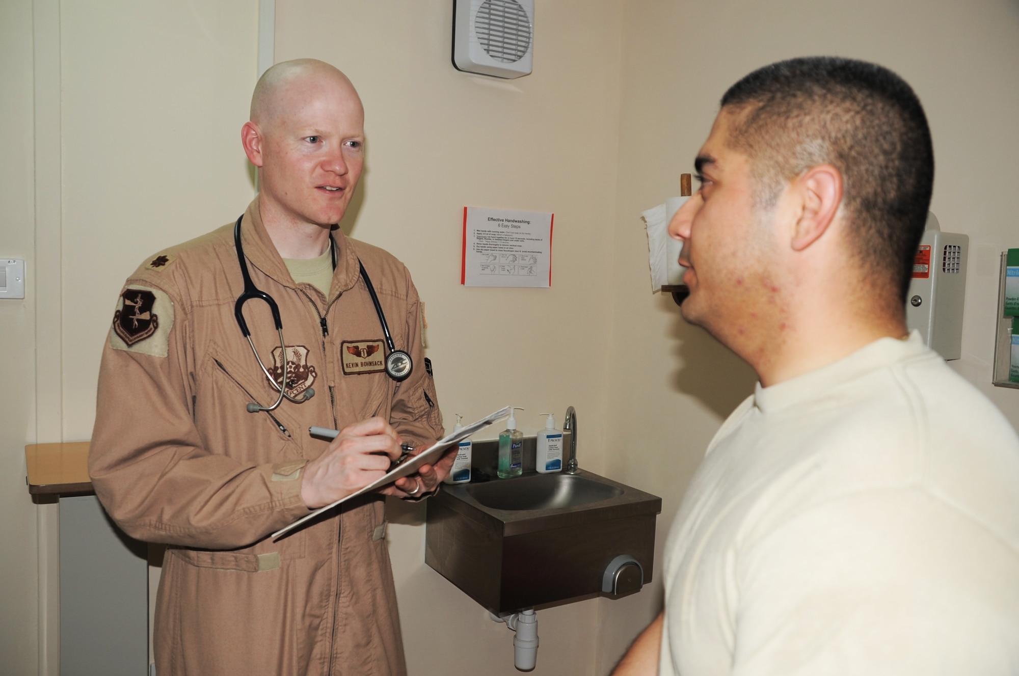 Maj. (Dr.) Kevin Bohnsack, chief of aerospace medicine for the 380th Expeditionary Medical Group, talks with a patient in the base medical clinic during operations at a non-disclosed base in Southwest Asia on April 5, 2010. As a deployed medical doctor, Major Bohnsack leads the effort to care for aircrews of the 380th Air Expeditionary Wing who fly combat air missions every day and he supports the medical clinic in taking care of deployed service members. The major is deployed from the 55th Medical Group at Offutt Air Force Base, Neb., and his hometown areas are Marquette, Brighton and Ann Arbor, Mich.  (U.S. Air Force Photo/Master Sgt. Scott T. Sturkol/Released)