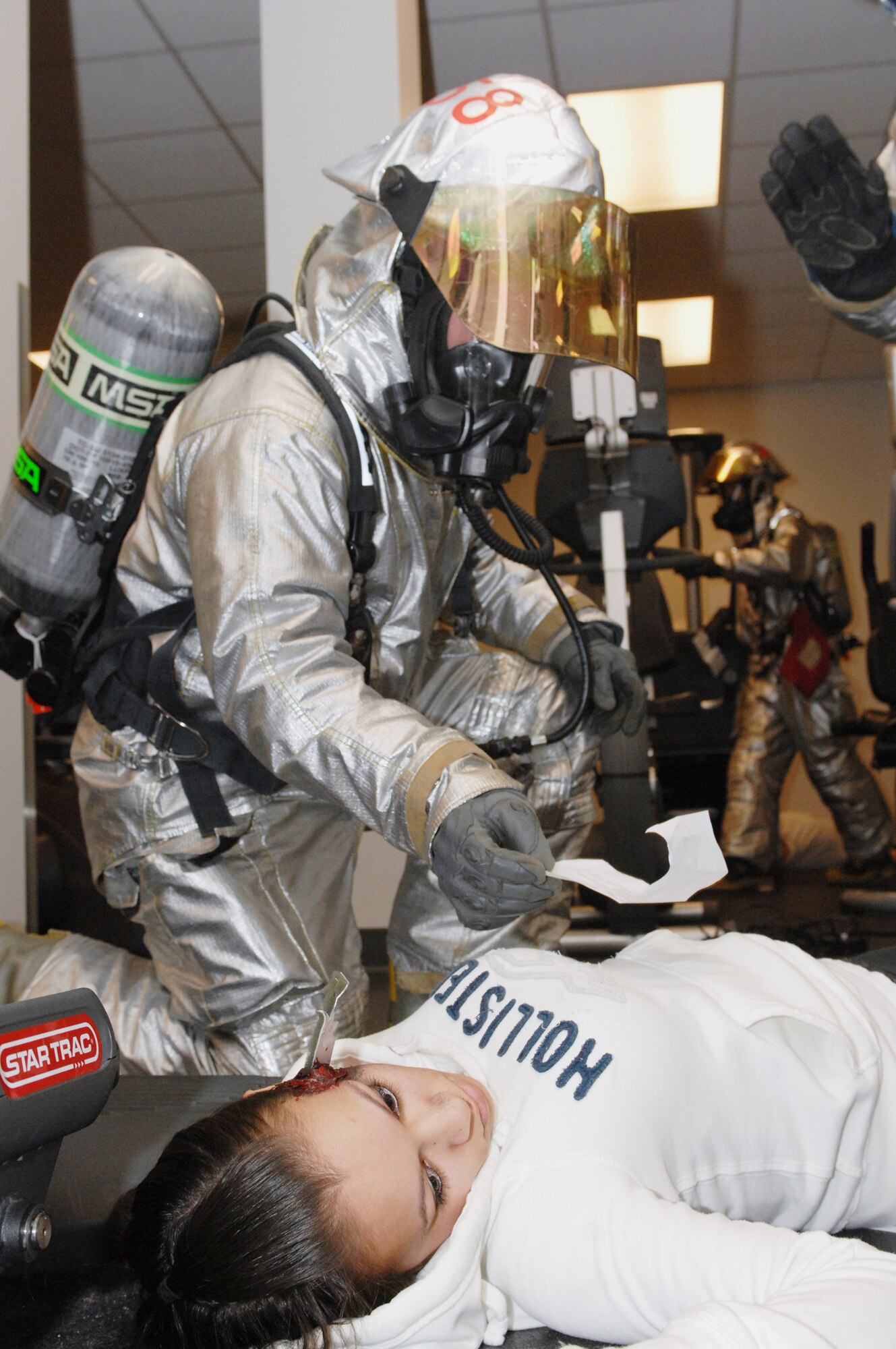 A base firefighter assists simulated victim Airman 1st Class Summer Mancilla during a major accident response exercise March 26, 2010, at Minot Air Force Base, N.D. The exercise prepared base members for possible real-world situations as well as testing communication and emergency procedures. Airman Mancilla is a 5th Maintenance Operations Squadron scheduler. (U.S. Air Force photo/Airman 1st Class Aaron-Forrest Wainwright)