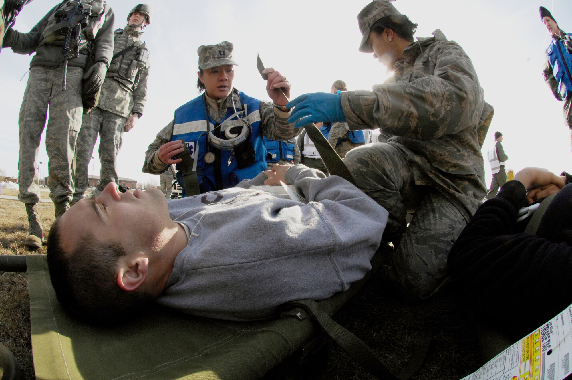 Capt. Tomao Rose and Senior Airman Erika Jenkins assess and treat simulated victim Airman 1st Class Thomas Kennedy during a major accident response exercise March 26, 2010, at Minot Air Force Base, N.D. The exercise prepared base members for possible real-world situations as well as testing communication and emergency procedures. Captain Rose and Airman Jenkins are assigned to the both 5th Medical Operations Squadron. Airman Kennedy is assigned to the 91st Missile Maintenance Squadron. (U.S. Air Force photo/Senior Airman Jesse Lopez)