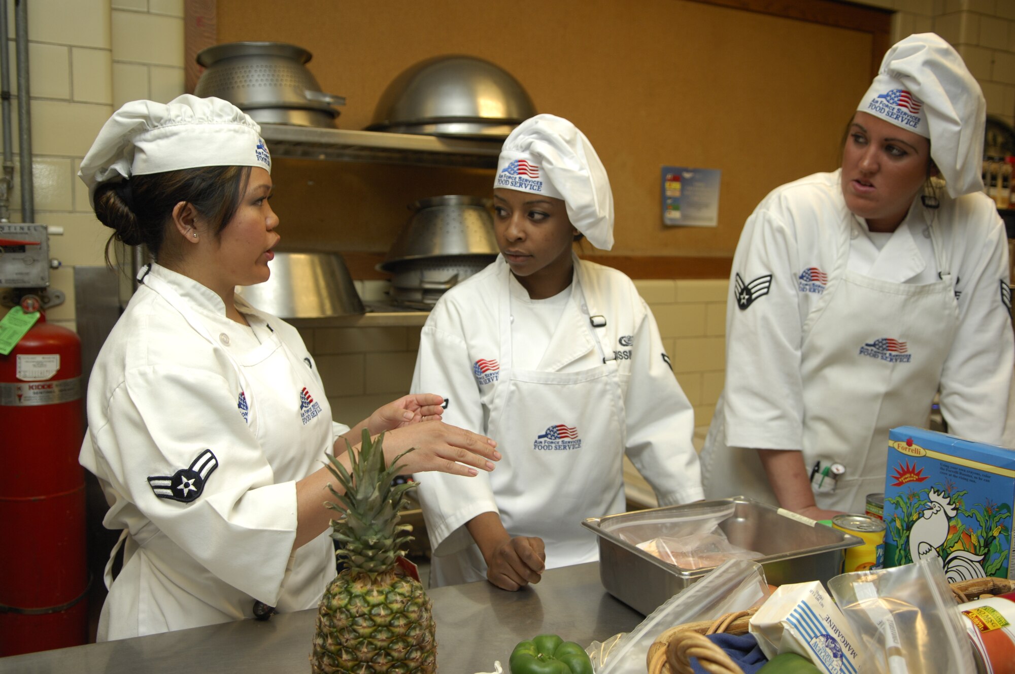 MINOT AIR FORCE BASE, N.D. -- The team of chefs from the 5th Bomb Wing discuss their game plan for the dishes they will make during the 2010 Warrior Chef competition held at the Dakota Inn dining facility on Minot Air Force Base March 30.  The two teams were required to use a surprise ingredient, which was pineapple. (U.S. Air Force photo by Airman 1st Class Ashley N. Avecilla)