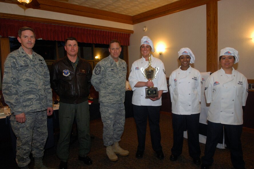 MINOT AIR FORCE BASE, N.D. – Col. James Gallagher, 5th Mission Support Group commander, Col. Julian Tolbert, 5th Bomb Wing Vice commander and Chief Master Sgt. Martin James, 5th BW command chief, present the team of chefs from the 5th BW the winning trophy for the 2010 Warrior Chef competition held at the Dakota Inn dining facility here March 30. The competition is an annual contest implemented to give 5th BW and 91st Missile Wing chefs the chance to show off their cooking abilities and creativity in a friendly competitive environment.  Each Wing must demonstrate culinary arts and talents in a 60 minute, head-to-head showdown to create the best main dish and side dish. (U.S. Air Force photo by Senior Airman Jesse Lopez)