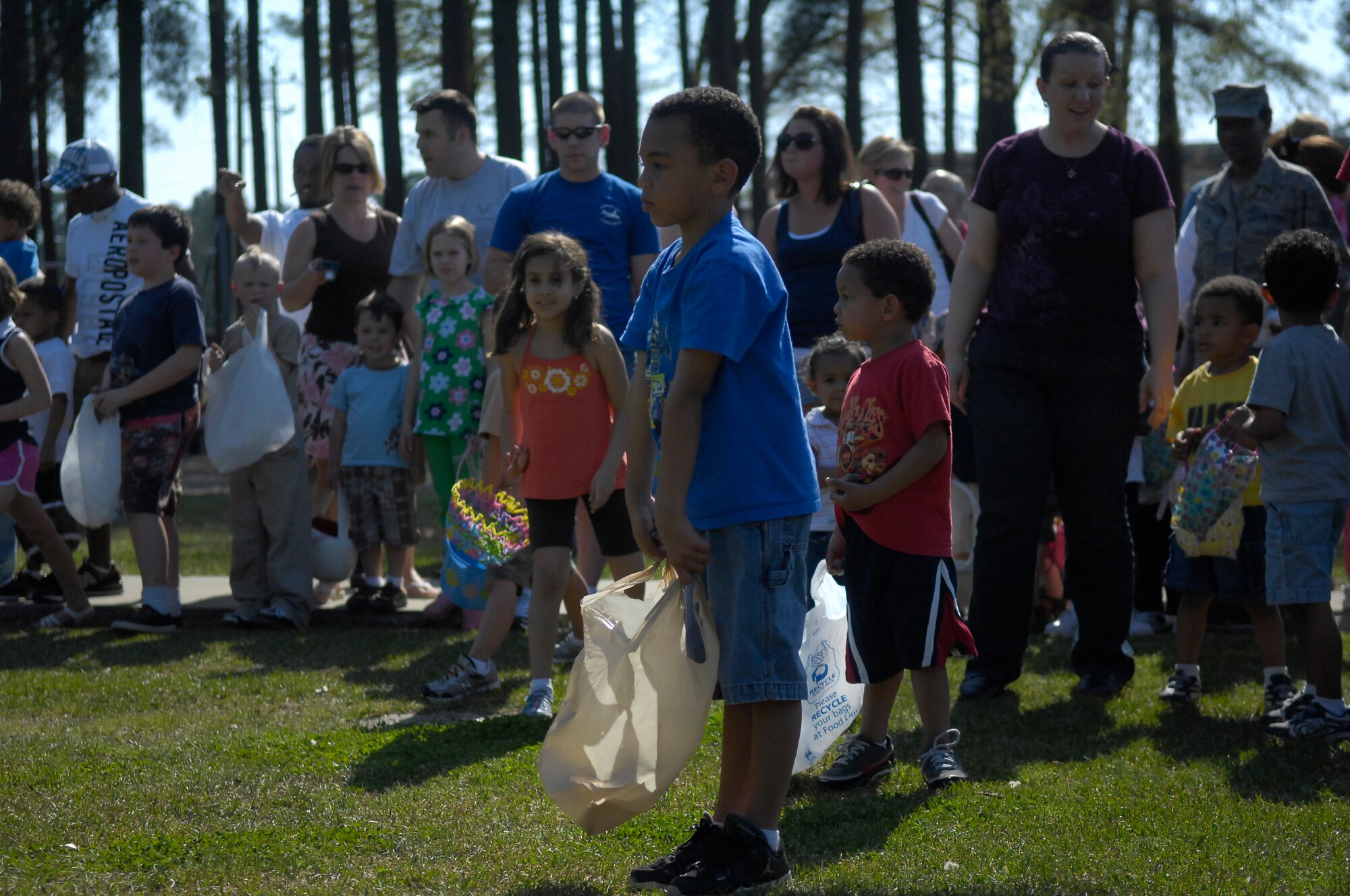 Children wait at the starting line before rushing forward to find Easter Eggs hidden throughout Woodland Park. (U.S. Air Force Photo by 2nd Lt. Cammie Quinn)