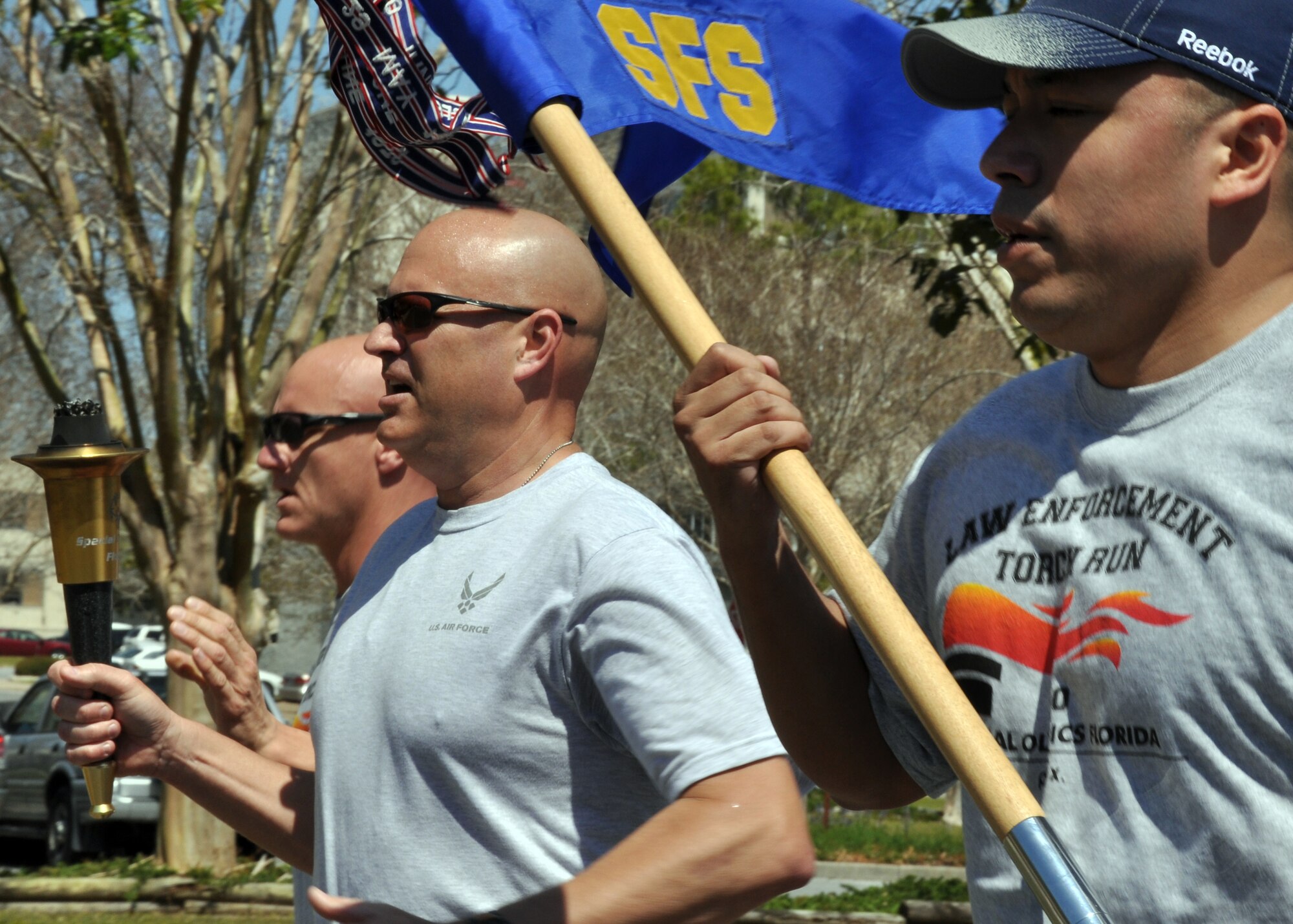 EGLIN AIR FORCE BASE, Fla. – (left to right) Master Sgt. Todd Coning, 96th Ground Combat Training Squadron, Master Sgt. Michael Bullard and Tech. Sgt. Gabriel Gonzalez, 96th Security Forces Squadron, carry the torch and guide-on during the 12th Annual Florida Torch Run, March 31. The event is a grassroots program supported by local police departments as a fundraiser for the Special Olympics. The Niceville Police Department handed the Torch of Hope to 96th SFS who then handed it to Fort Walton Beach Police Department. (U.S. Air Force photo/ Airman 1st Class Anthony Jennings)