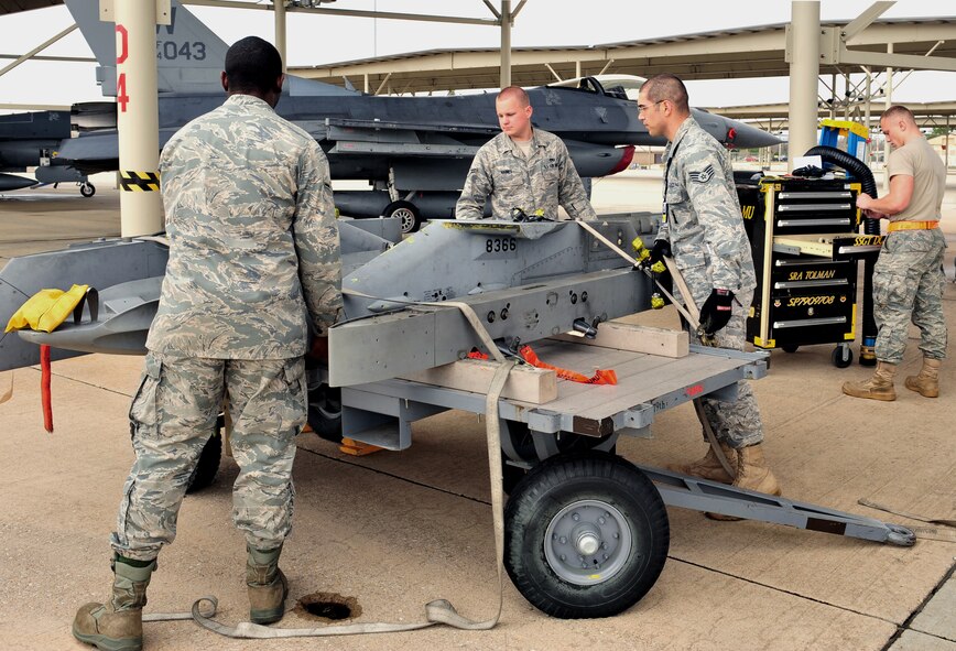 SHAW AIR FORCE BASE, S.C. -- Airman Braxton Betts (left), Staff Sgt. Gerald Ratulowski (right), and Airman 1st Class Wesley Haines, 79th Aircraft Maintenance Unit, secure equipment to a loading cart here March 12. Airman Betts, Staff Sgt. Ratulowski, and Airman 1st Class Haines specialize as weapon loaders for the unit. The 79th AMU is dedicated to mission readiness and frequently trains to ensure consistent quality of work. (U.S. Air Force photo/Airman 1st Class Amber E. N. Jacobs)