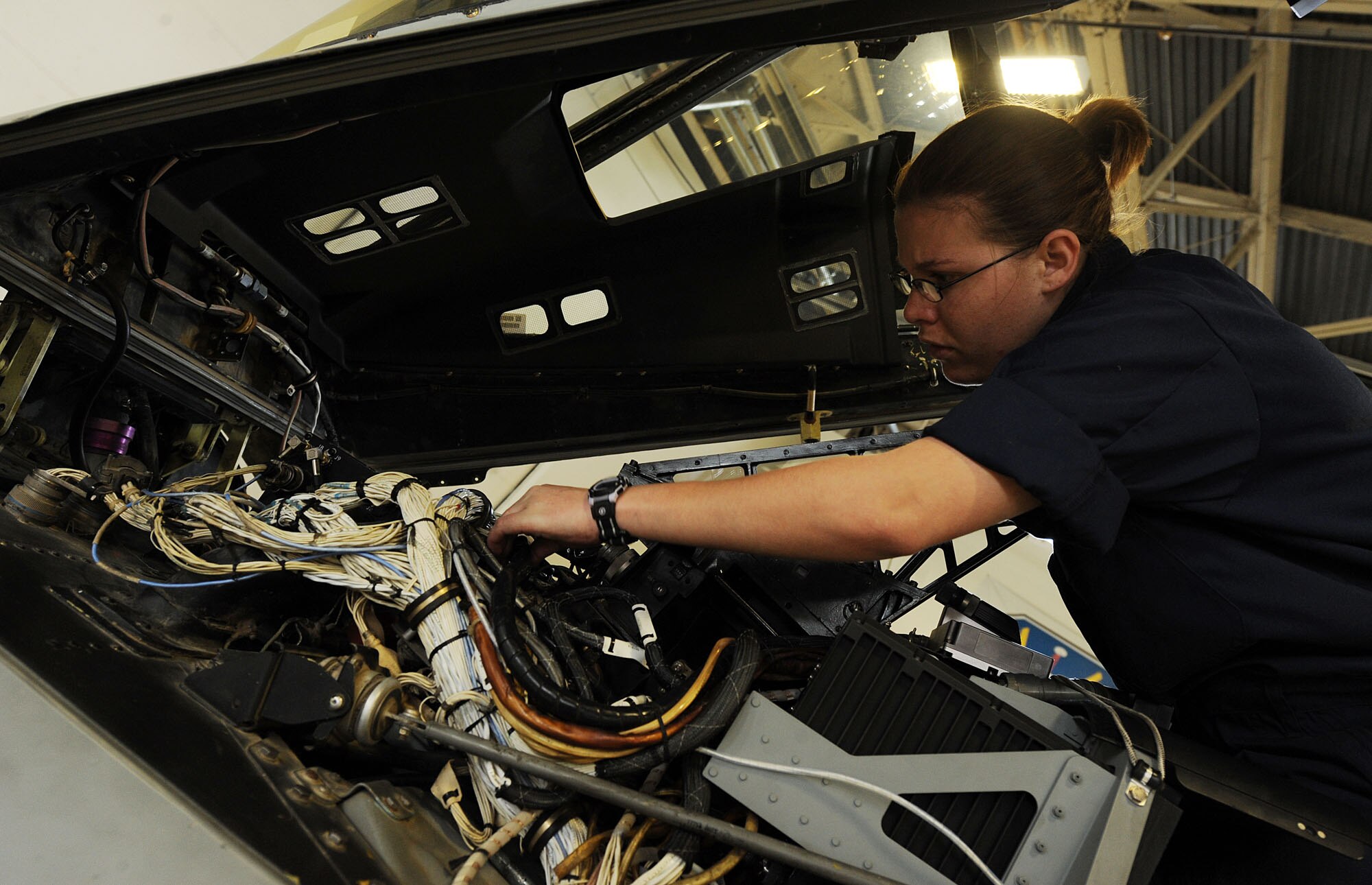 MOODY AIR FORCE BASE, Ga. -- Staff Sgt. Erin Carrier, 23rd Equipment Maintenance Squadron A-10C Thunderbolt II crew chief, inspects wire from the cockpit of an A-10C during a phase doc inspection here March 24. The phase doc process is a 10 day in-depth inspection of the A-10C and is used as a time saving measure in which all areas of the aircraft is inspected. (U.S. Air Force photo by Airman 1st Class Joshua Green/RELEASED)