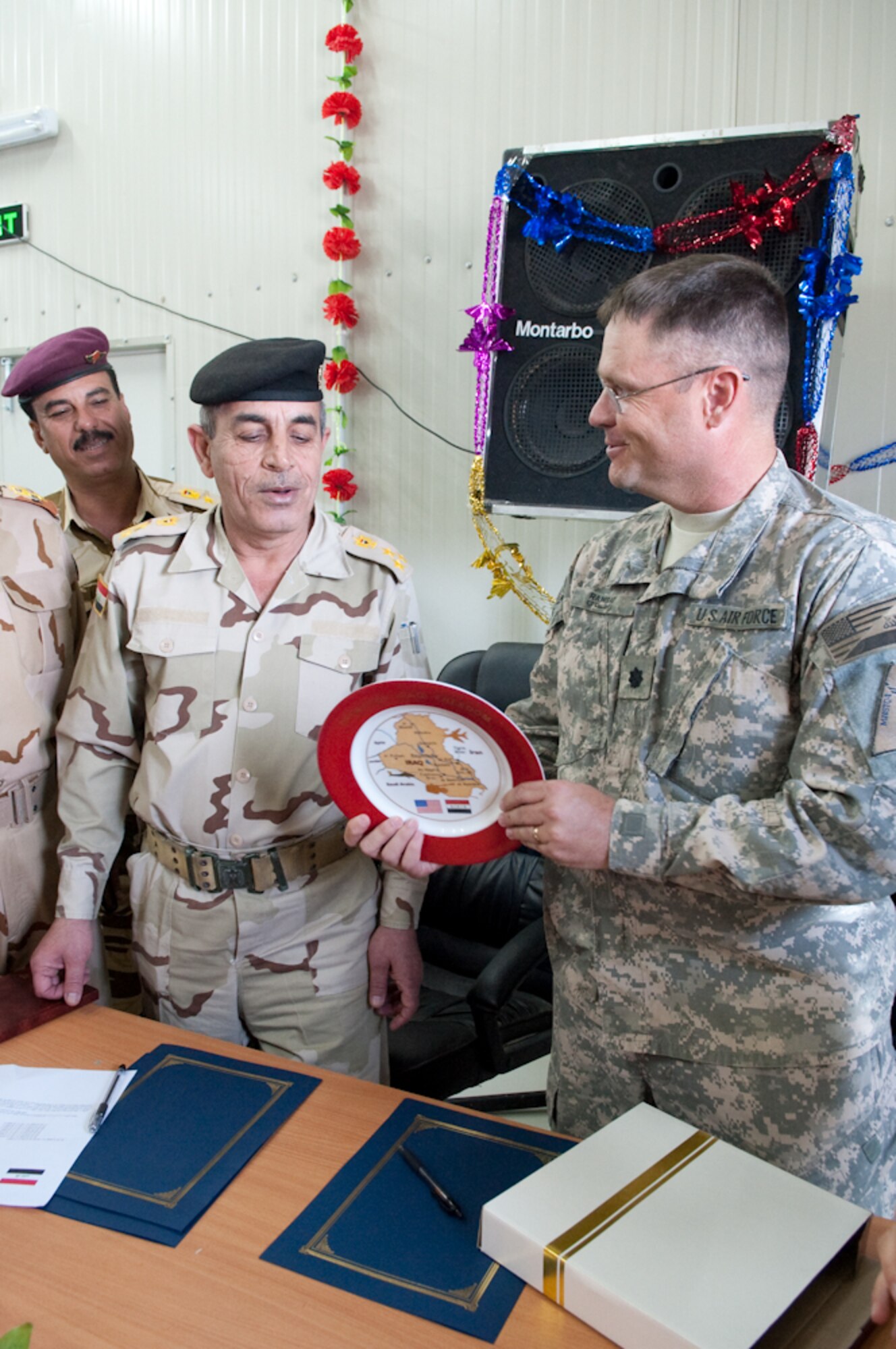 U.S. Air Force Lt. Col. Steven Ramsay, senior advisor, 4th Brigade Combat Team 1st Armored Division, Logistics Military Advisory Team, Joint Expeditionary Tasking Airman assigned to the U.S. Army presents  a gift to Iraq Staff Brig. Gen Hassan, location commander for Camp Ur, a ceremonial plate signifying the lasting partnership between the Logistics Mission Advisory Team and Iraq Army during the Ribbon Cutting Ceremony at Camp Ur, Iraq, March 28, 2010.  The signing over of Camp Ur is another successful mission for the LMAT. (U.S. Air Force Photo/Senior Master Sgt. Elizabeth Gilbert. Released)