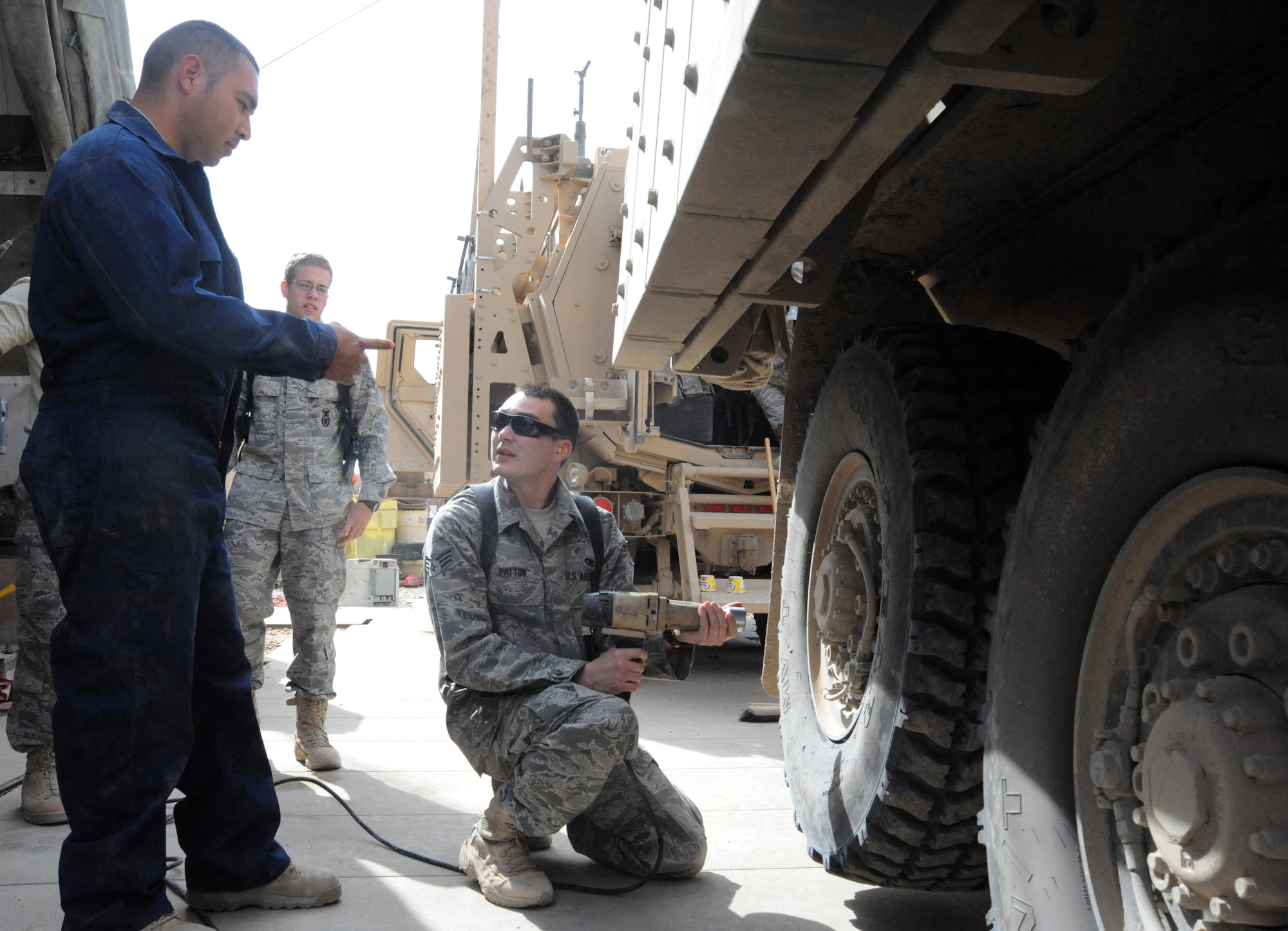 Air Force Staff Sgt. Juan Hurtado (left), 732nd Expeditionary Security Forces Squadron maintenance technician, Senior Airmen Jordan Purdue (center) and Zachery Patton discuss the proper tire changing procedures for a Mine Resistant Ambush Protected vehicle, Camp Stryker, Iraq, March 25, 2010.  Before each inspection, the “Reapers” go through a checklist that includes checking the oil, tire pressure and searching for leaks. There is always a qualified vehicle maintainer watching to make sure everything is done correctly.  (U.S. Air Force photo/Master Sgt. Trish Bunting/Released)