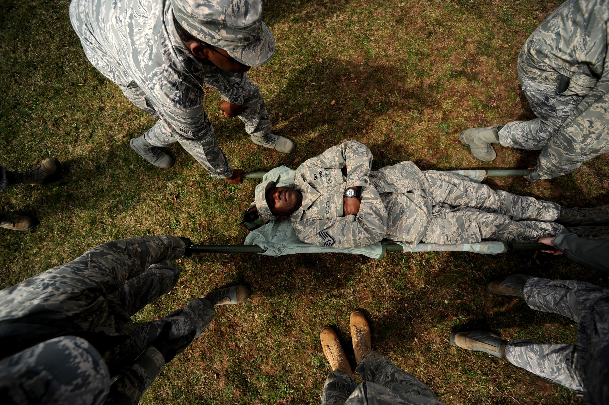 U.S. Air Staff Sgt. Karriem Oliver, 86th Airlift Wing Staff Agency, chaplain's assistant, simulates a wounded member during the improvised litter portion of self aid and buddy care training in support of the upcoming Operations Readiness Inspection (ORI), April 2, 2010, Ramstein Air Base, Germany. Preparation for the ORI allows Air Force members to build on strengths and indentify weaknesses in order to better support future missions. (U.S. Air Force photo by Tech. Sgt. Sarayuth Pinthong)