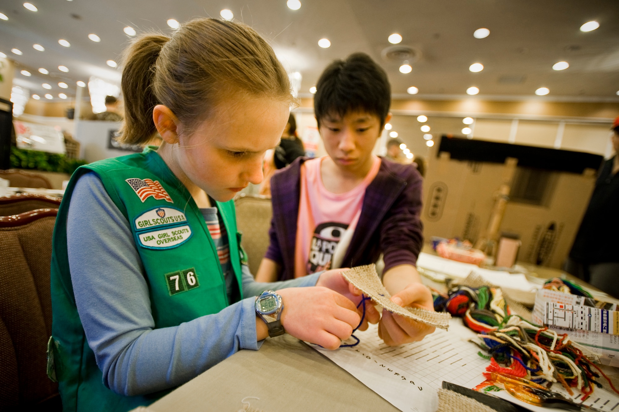 MISAWA AIR BASE, Japan -- Catherine DeJager, with the assistance of Noritake Toyoshima, makes kogin embroidery during the 23rd Annual Japan Day April 3 at the Misawa Collocated Club. Japan Day featured Japanese events, activities and entertainment for Misawa service members and their families. (U.S. Air Force photo/Senior Airman Jamal D. Sutter)