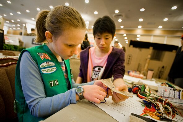 Catherine DeJager, with the assistance of Noritake Toyoshima, makes kogin embroidery during the 23rd Annual Japan Day April 3, 2010, at the Misawa Collocated Club, Misawa Air Base, Jaopan. Japan Day featured Japanese events, activities and entertainment for Misawa service members and their families. (U.S. Air Force photo/Senior Airman Jamal D. Sutter) 