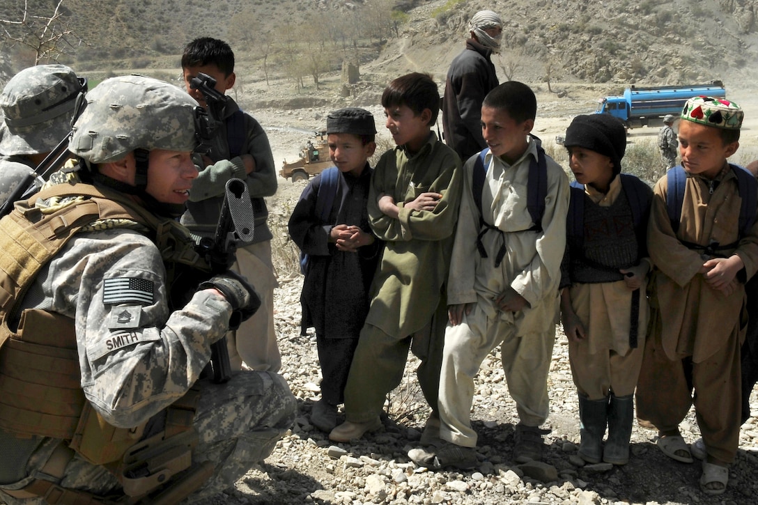U.S. Army Sgt. 1st Class Ian Smith hands candy to children during a civil assistance mission along the Khost-Gardez Pass in eastern Afghanistan, March 29, 2010. Smith is assigned to the 82nd Airborne Division's Regimental Corp Training Team 2, Indiana National Guard. The Afghan National Army organized the mission with the aid of coalition forces, coordinated the movement of supplies and controlled the mission's security while distributing school supplies to villagers.