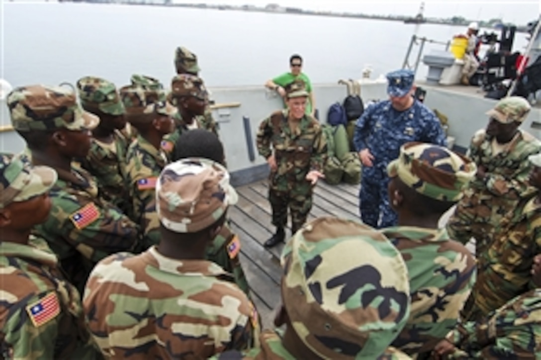 U.S. Navy Capt. Cindy Thebaud, African Partnership Station West commander, and Lt. Cmdr. Timothy Labenz, operations officer, speak to a group of 17 Armed Forces of Liberia Coast Guardsmen while transiting to the amphibious dock-landing ship USS Gunston Hall off West Africa, April 1, 2010. The Liberian Coast Guardsmen are embarking on the Gunston Hall for training in maritime safety and security.