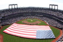 Soldiers, sailors, airmen and Marines participate in the Met's 2010 season opener, unveiling the American flag at Citi Field April 5. Marines with 1st Marine Corps District, 2nd Battalion, 25th Marines and 6th Communications Battalion joined other service members from the area to participate in the event.