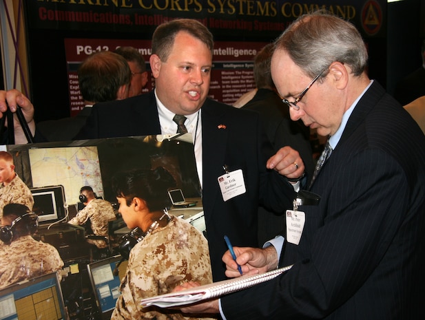 Erik Gardner of Marine Air-Ground Task Force Command and Control, Weapons and Sensors Development and Integration Product Group, speaks with an attendee during the 2010 Advanced Planning Briefing to Industry.