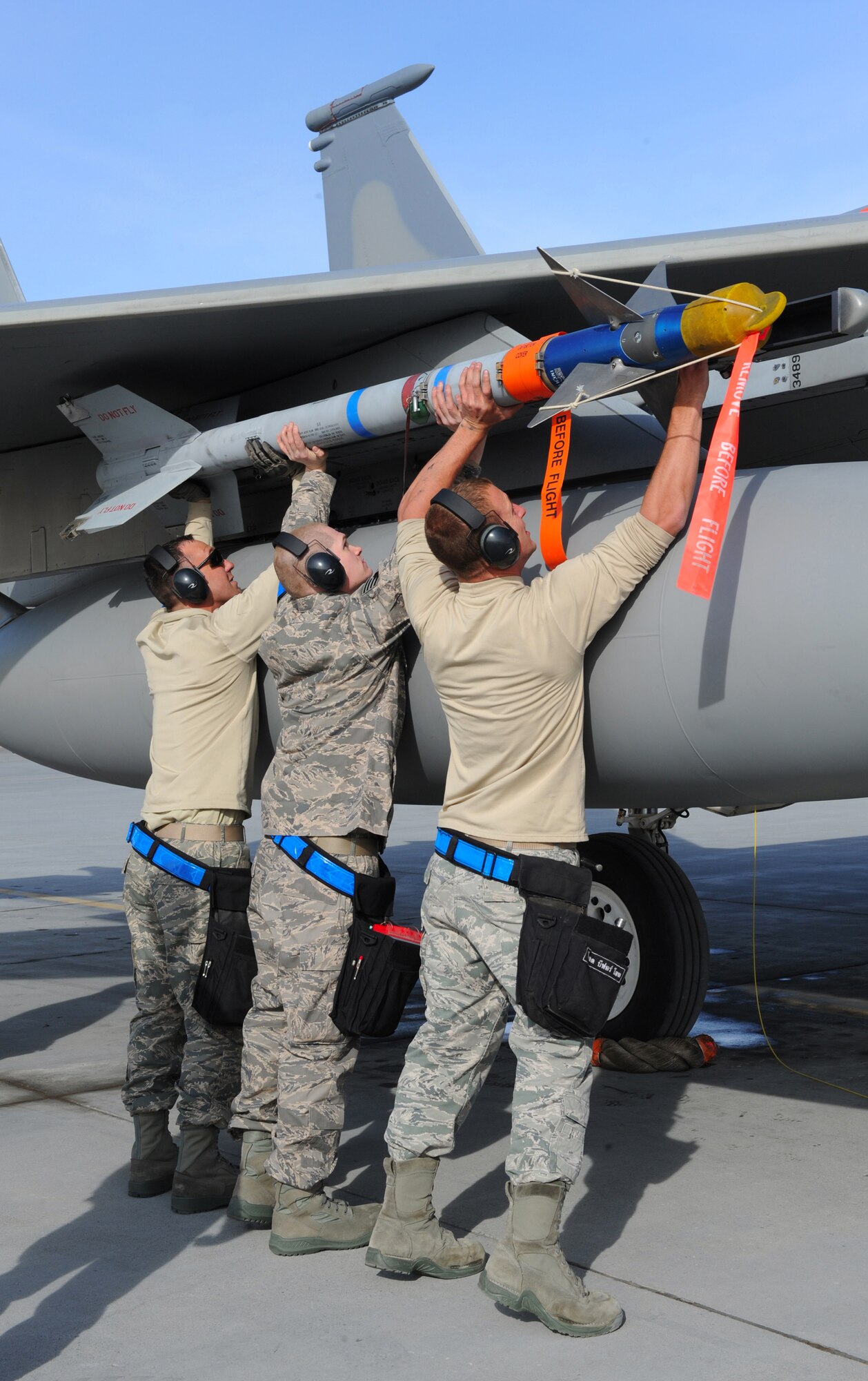 ELMENDORF AIR FORCE BASE, Alaska -- The 19th Aircraft Maintenance Unit's load crew team loads an Air Intercept Missile 9, on an F-15 aircraft launcher during a load competition April 2. Three load teams from the 3rd Wing’s Aircraft Maintenance Units participated in a load crew competition on the flight line. (Air Force photo by Senior Airman Cynthia Spalding)