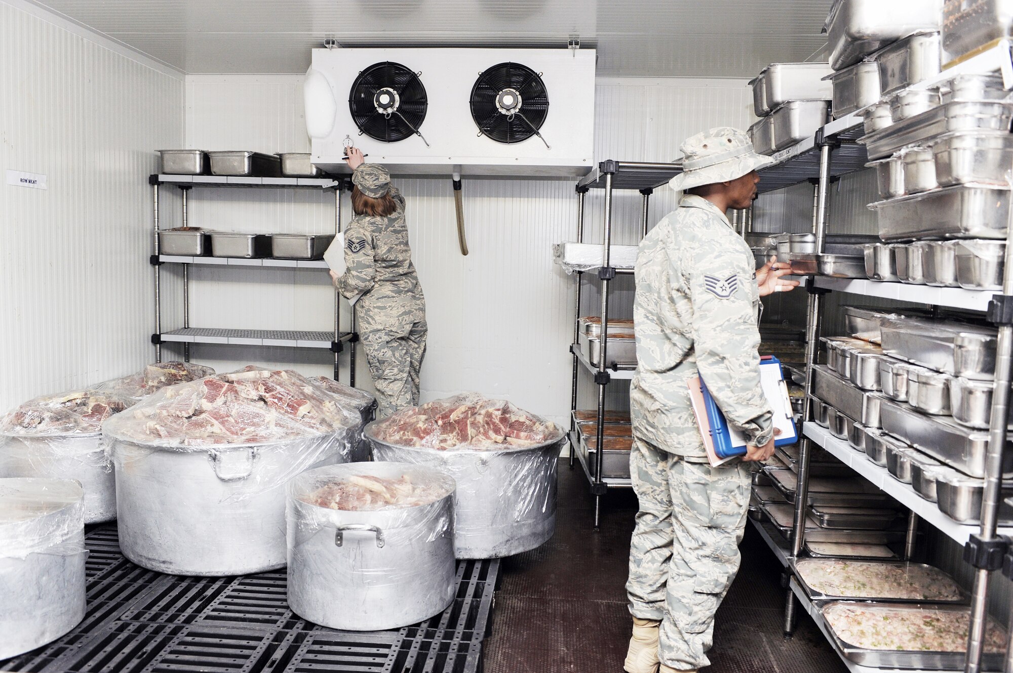 Staff Sgts. Jennifer Ledward (left) and William Crenshaw check the temperature, dates and storage of the "first in, first out" refrigerator during an inspection of Dining Facility Two March 23, 2010, at Joint Base Balad, Iraq. Both sergeants are public health technicians with the 332nd Aerospace Medical Squadron. Sergeant Ledward is deployed from Beale Air Force Base, Calif., and Sergeant Crenshaw is deployed from Lackland AFB, Texas. (U.S. Air Force photo/Master Sgt. Linda C. Miller)