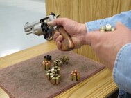 MINOT, N.D. -- A member of the Minot Rifle and Pistol Club demonstrates the procedures in loading a revolver at an indoor rifle range April 5. (U.S. Air Force photo by 2nd Lt. Kidron B. Vestal)