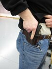MINOT, N.D. -- A member of the Minot Rifle and Pistol Club demonstrates placement of his concealed weapon at an indoor rifle range April 5. (U.S. Air Force photo by 2nd Lt. Kidron B. Vestal).