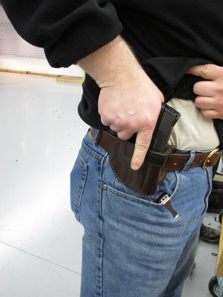 MINOT, N.D. -- A member of the Minot Rifle and Pistol Club demonstrates placement of his concealed weapon at an indoor rifle range April 5. (U.S. Air Force photo by 2nd Lt. Kidron B. Vestal).