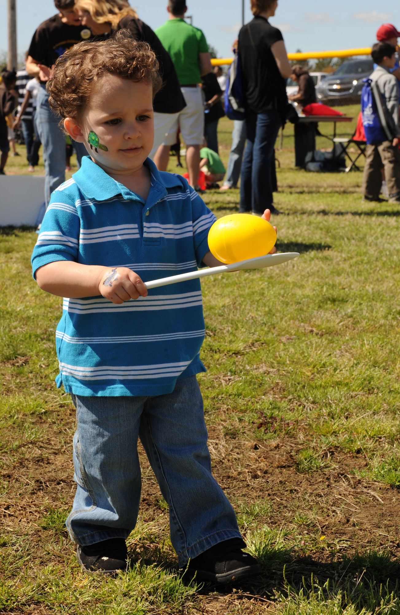 Nicholas Nye, 2, son of Staff Sgt. Stephanie Nye, 19th Aircraft Maintenance Squadron electronic warfare technician, and Staff Sgt. Ronnie New, 19th AMXS intergraded avionics, cautiously navigates the egg relay course April 3. The egg relay was one of the many activities held at the “It’s All About YOUth” festival and egg hunt organized to launch Month of the Military Child. (U.S. Air Force photo by Staff Sgt. Chad Chisholm)