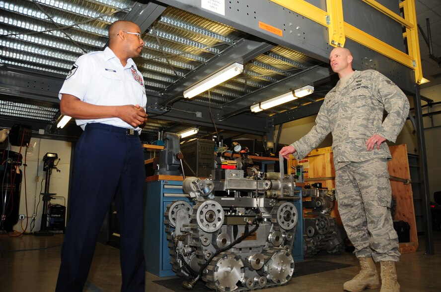 ELLSWORTH AIR FORCE BASE, S.D. -- (Left to right) Master Sgt. Anthony Blackmon, 28th Civil Engineer Squadron explosive ordinance disposal flight chief and Staff Sgt. Patrick Heltne, 28 CES EOD resources manager, discuss the advancements in robotics with Lt. Col. Matthew Joganich, 28 CES commander, April 5.  Many EOD Airmen now use robots that are both smaller and more portable, allowing for greater accessibility in the deployed environments. (U.S. Air Force photo/Airman 1st Class Anthony Sanchelli)