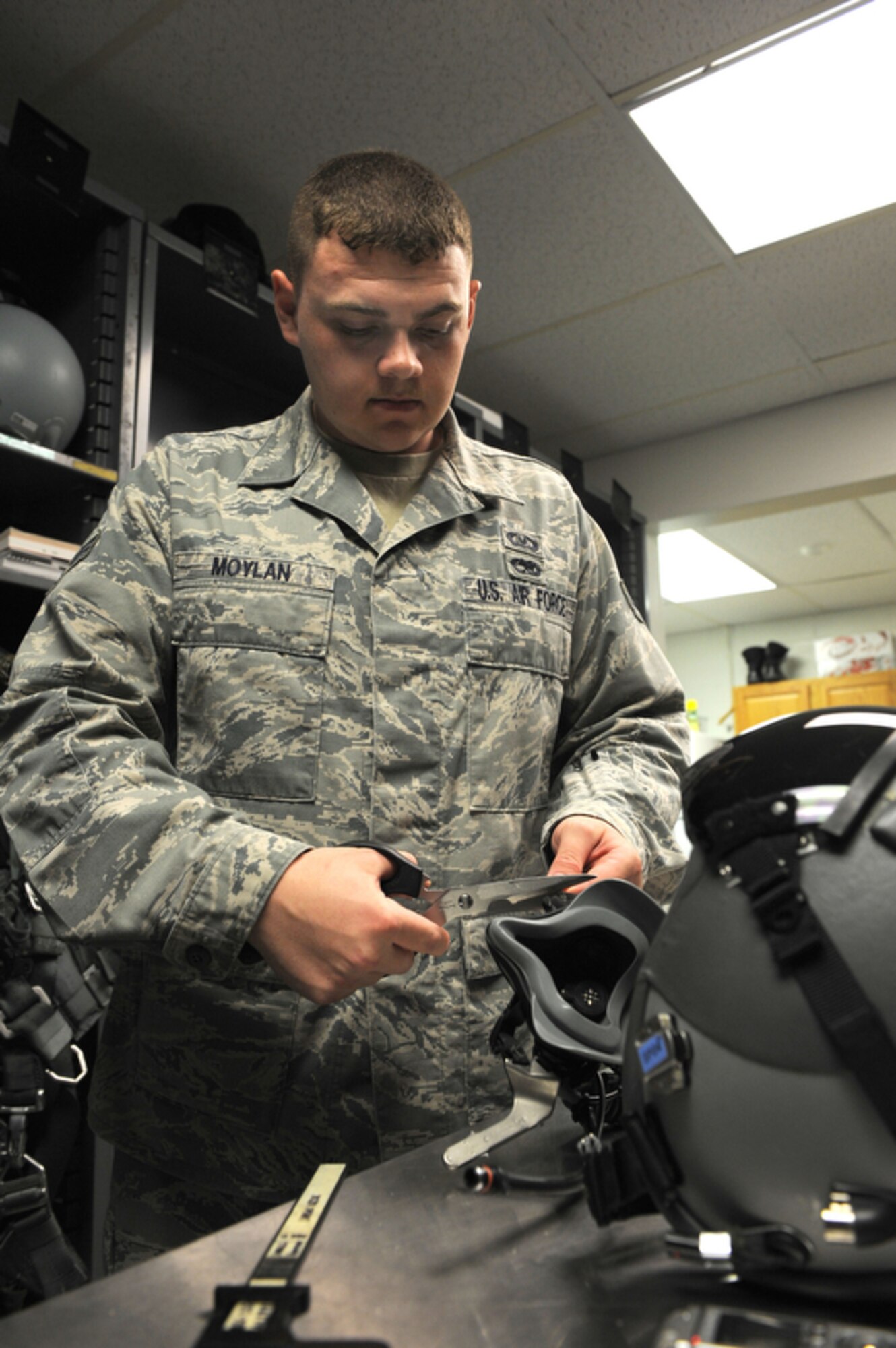 JOINT BASE PEARL HARBOR-HICKAM, Hawaii - Senior Airman Kenny Moylan, an aircrew flight equipment journeyman with the 19th Fighter Squadron, Elmendorf AFB, Alaska cuts excess wire that was weaved into an oxygen mask that will ensure it stays in place in case of an emergency on March 23, while at Joint Base Pearl Harbor-Hickam. This method is utilized when an incentive ride is given because incentive fliers are not familiar the flying equipment. Airman Moylan is supporting the 19th FS pilots while they participate in training exercise with the 199th FS of the Hawaii Air National Guard. (Air Force photo by Tech. Sgt. Cohen A. Young)