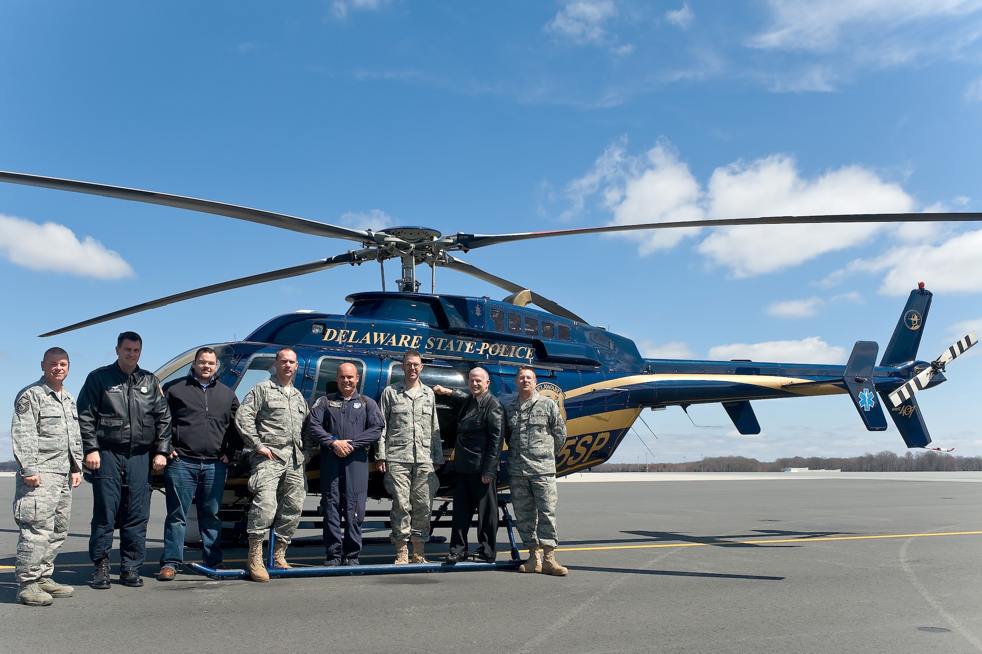 Team Dover members pose with members of the Delaware State Police Department after the completion of a joint mission to discover a broken heat plant line March 31. The DSPD offered aerial support along with their infra-red imaging equipment to assist the 436th Civil Engineer Squadron in locating a broken line that was releasing more than 10,000 gallons of hot water. (U.S. Air Force photo/ Roland Balik)