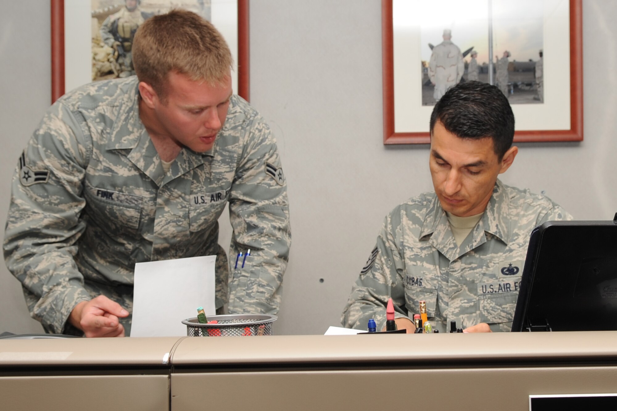 Tech. Sgt. Alexander Cubas, 1st Special Operations Logistics Readiness Squadron, right, reviews a document from Airman 1st Class Ethan Fink, 1st SOLRS, at the Hurlburt Field Deployment Control Center April 6. Sergeant Cubas was selected for this week's "Tip of the Spear" spotlight. (U.S. Air Force photo by Airman Caitlin O'Neil-McKeown)