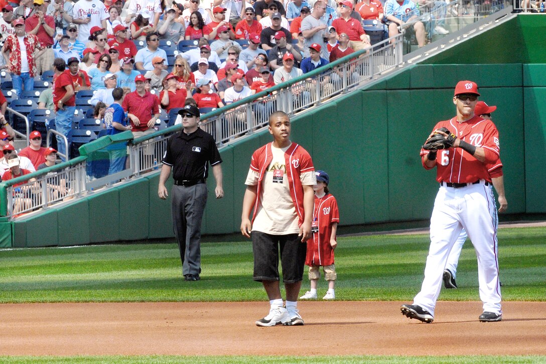 Izaiah Robinson (center) whose father is deployed in Bahrain, was one of nine military children with a deployed parent invited to spend the opening day of baseball season April 5, 2010, at Washington Nationals Ball Park in Washington, D.C. The children took the field with the Nationals' nine starting players and saw President Barack Obama throw out the first pitch. (DOD photo/Navy Petty Officer 2nd Class William Selby)
